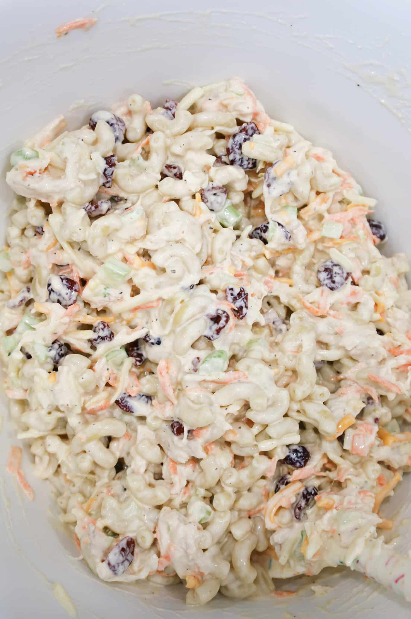 stirring all macaroni salad ingredients together in a mixing bowl