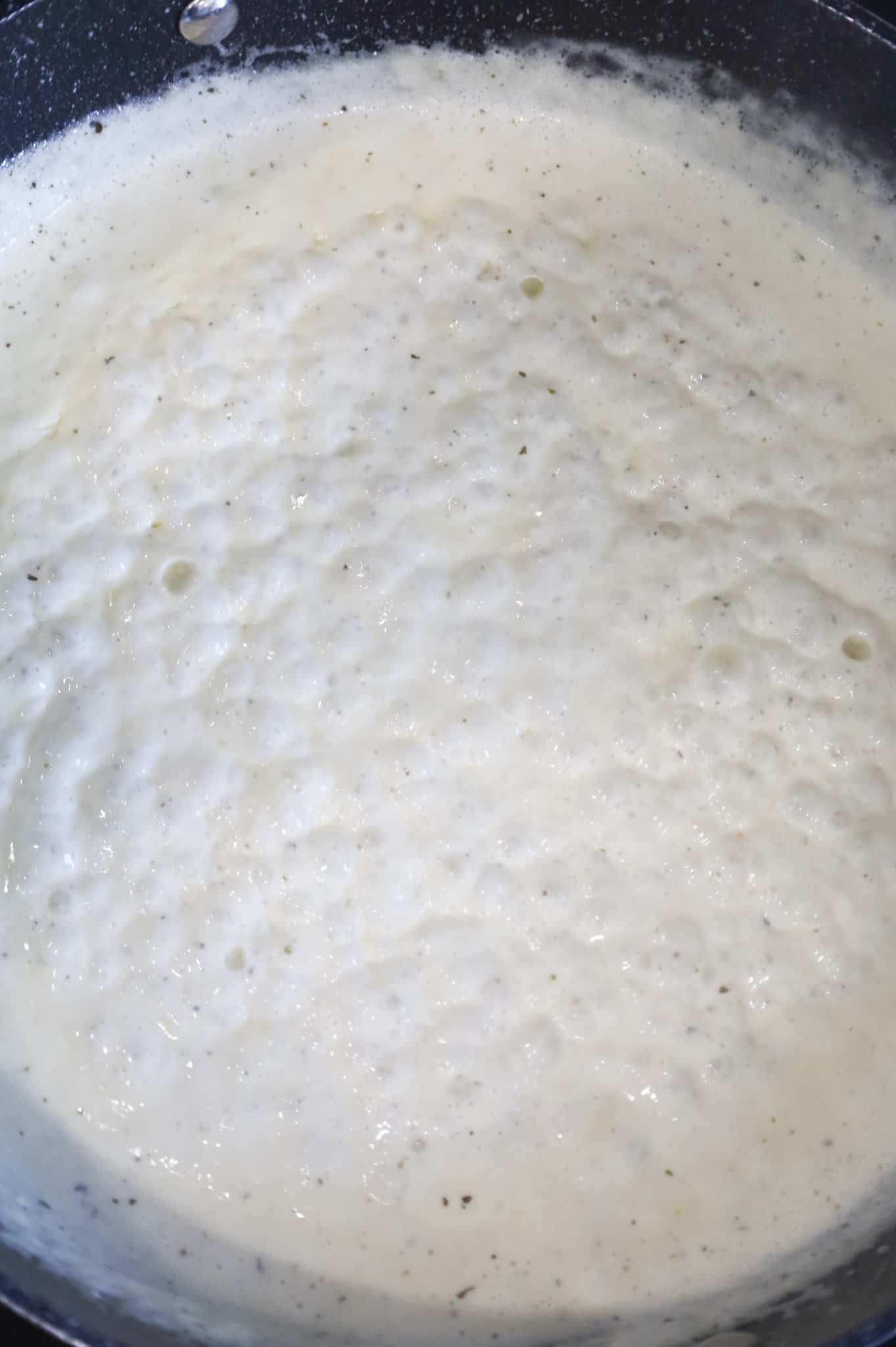 cream sauce simmering and thickening in a skillet