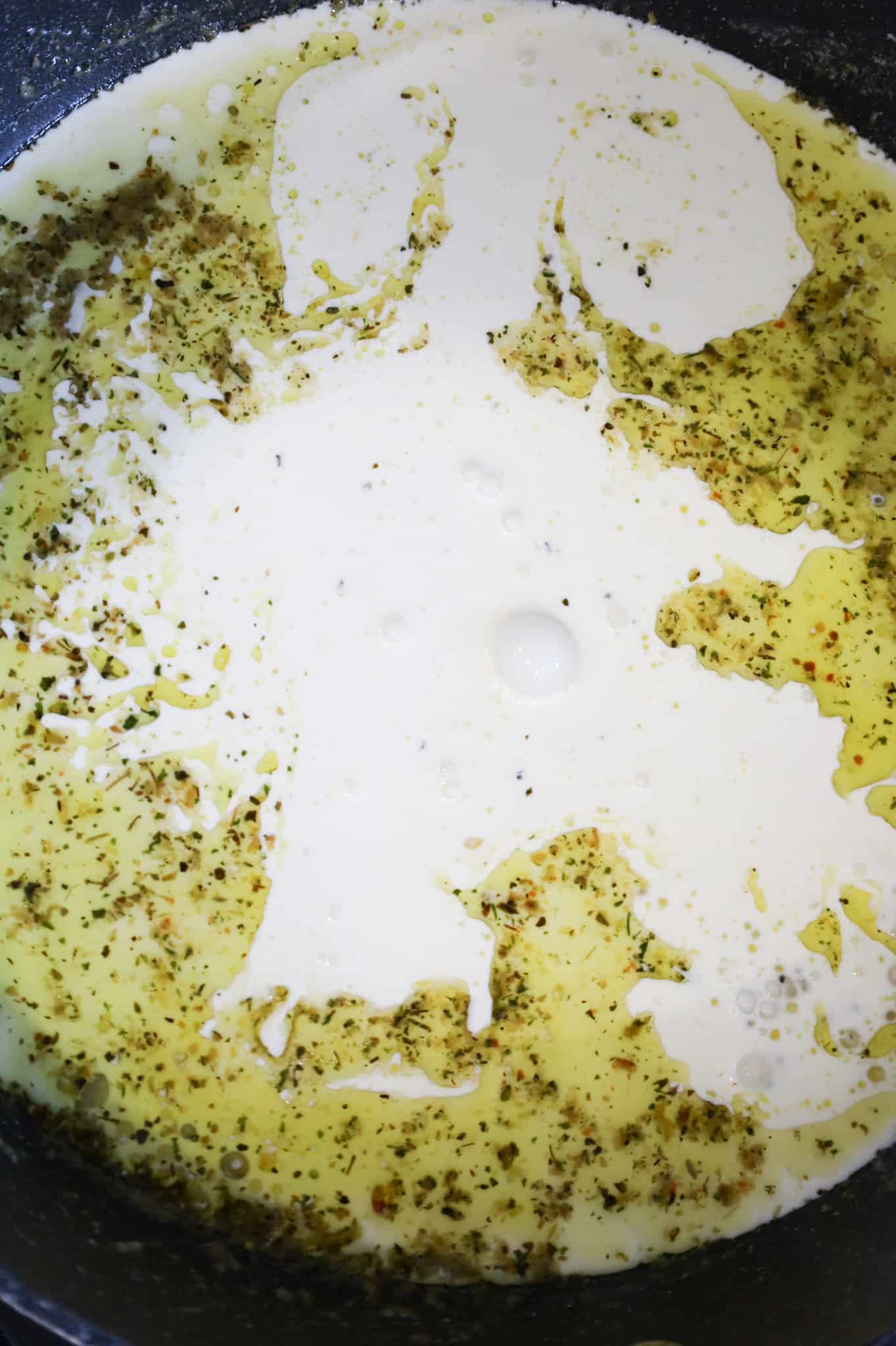 heavy cream added to skillet with melted butter, garlic puree and Italian seasoning
