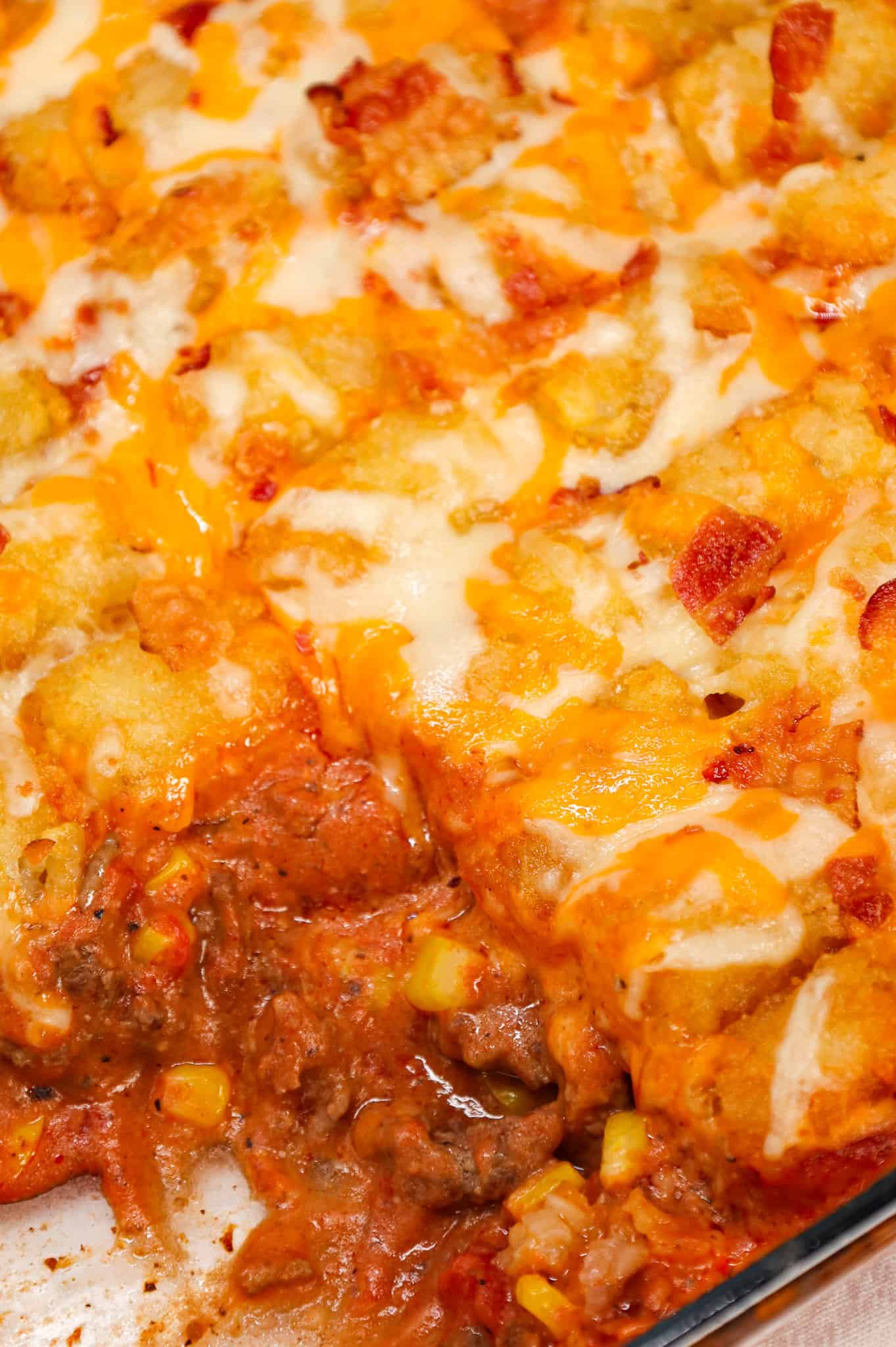 Cowboy Casserole is an easy ground beef casserole recipe loaded with diced tomatoes, corn, tater tots, shredded cheese and bacon.