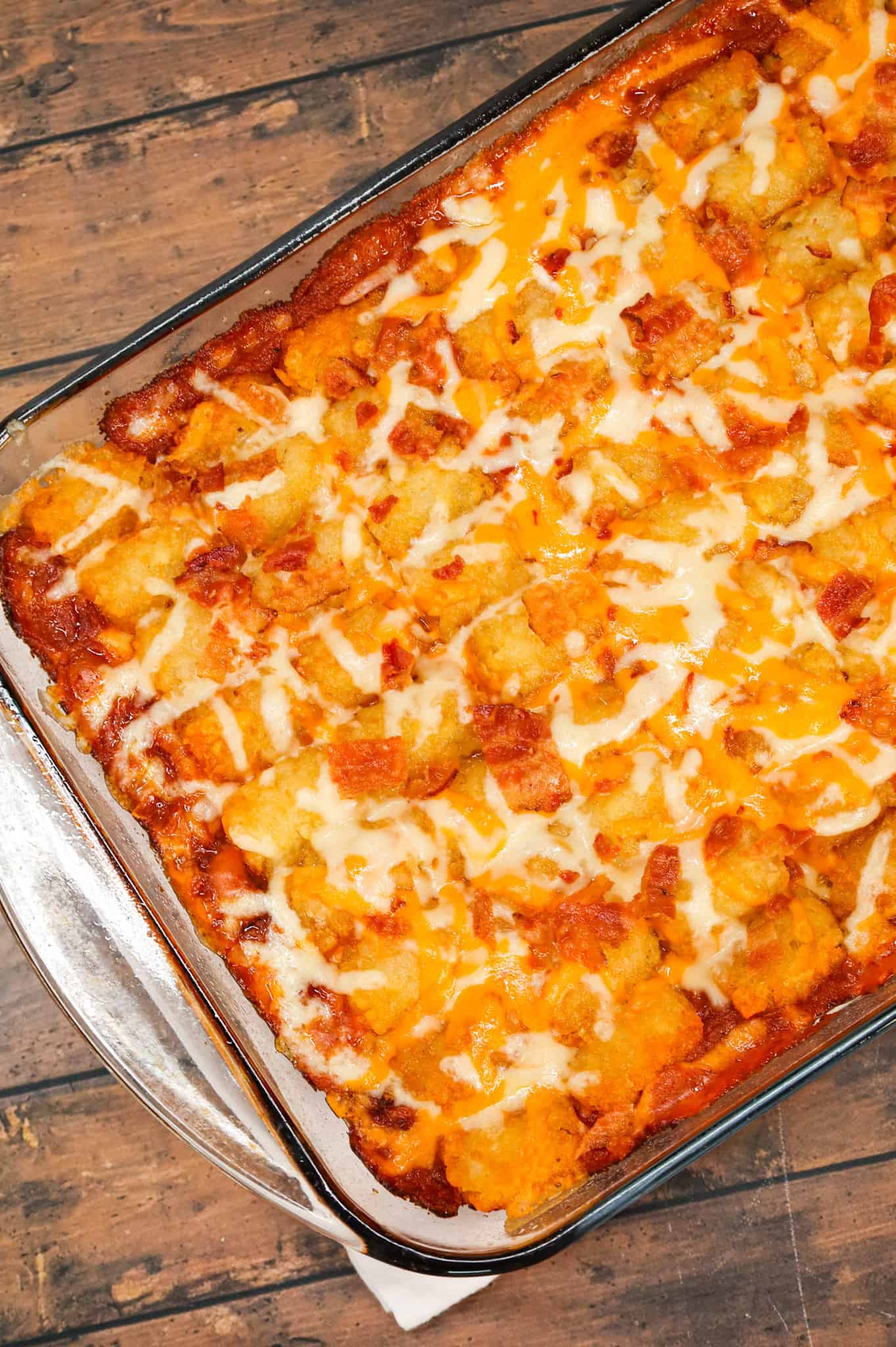 Cowboy Casserole is an easy ground beef casserole recipe loaded with diced tomatoes, corn, tater tots, shredded cheese and bacon.