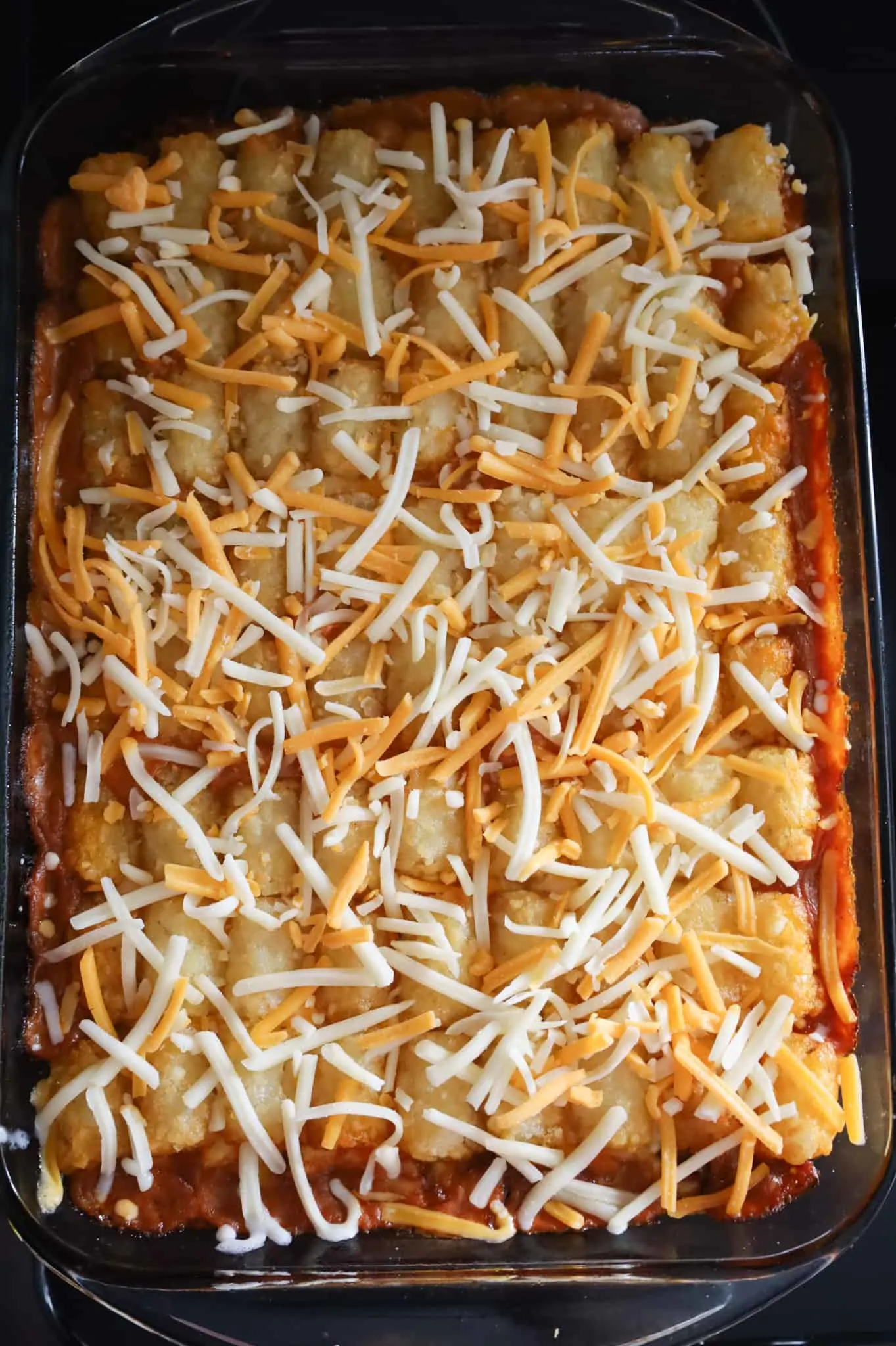 shredded cheddar cheese on top of tater tot casserole