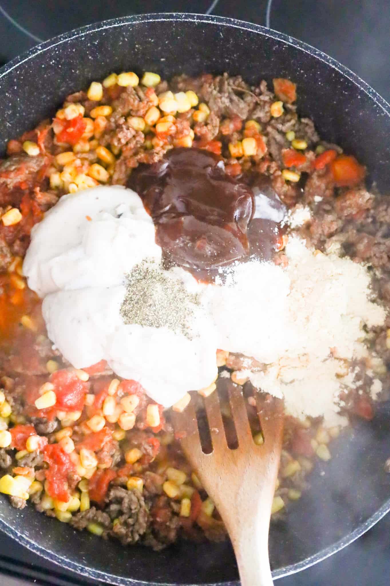 salt, pepper, onion powder and garlic powder, bbq sauce and cream of mushroom soup on top of ground beef mixture in a skillet