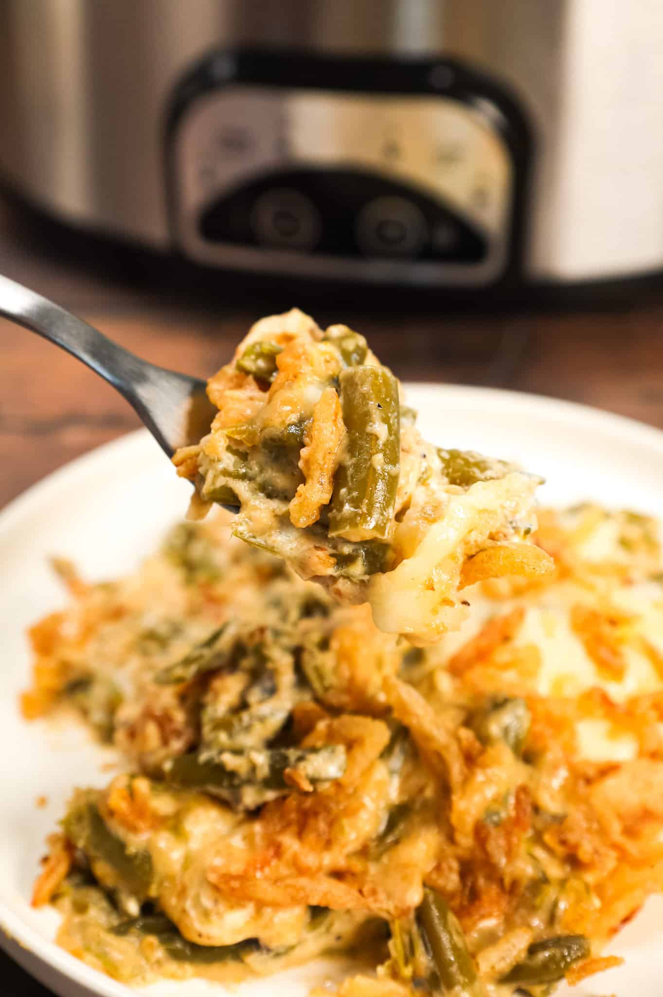 Crock Pot Green Bean Casserole is an easy slow cooker side dish recipe loaded with cut green beans, cream of mushroom soup, cheddar soup, cream cheese, provolone cheese and French's crispy fried onions.