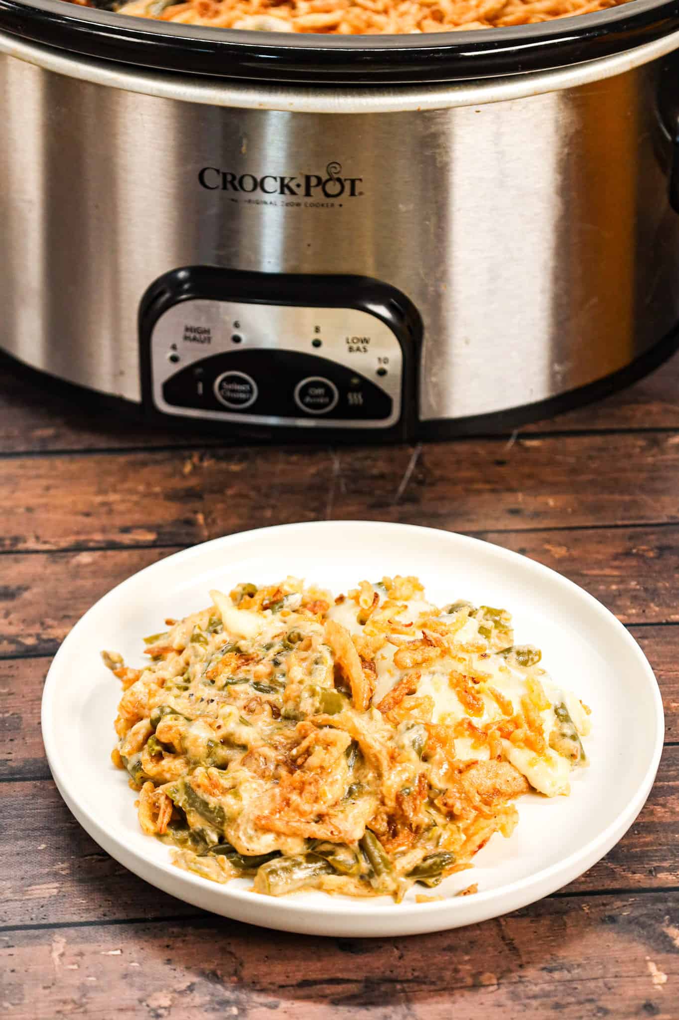 Crock Pot Green Bean Casserole is an easy slow cooker side dish recipe loaded with cut green beans, cream of mushroom soup, cheddar soup, cream cheese, provolone cheese and French's crispy fried onions.