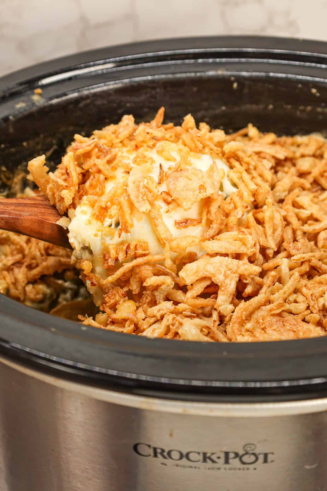 Crock Pot Green Bean Casserole is an easy slow cooker side dish recipe loaded with cut green beans, cream of mushroom soup, cheddar soup, cream cheese, provolone cheese and French's crispy fried onions.