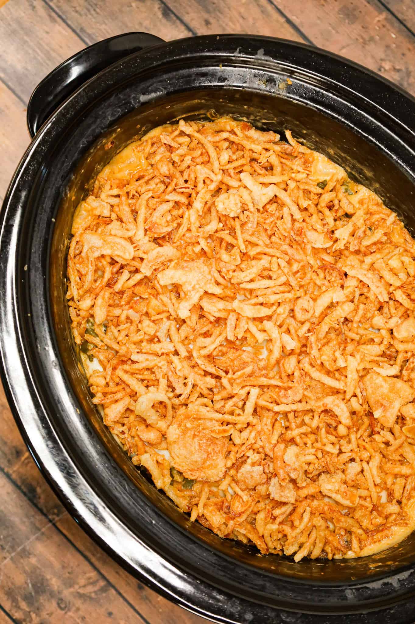 Crock Pot Green Bean Casserole is an easy slow cooker side dish recipe loaded with cut green beans, cream of mushroom soup, cheddar soup, cream cheese, provolone cheese and French's crispy fried onions.