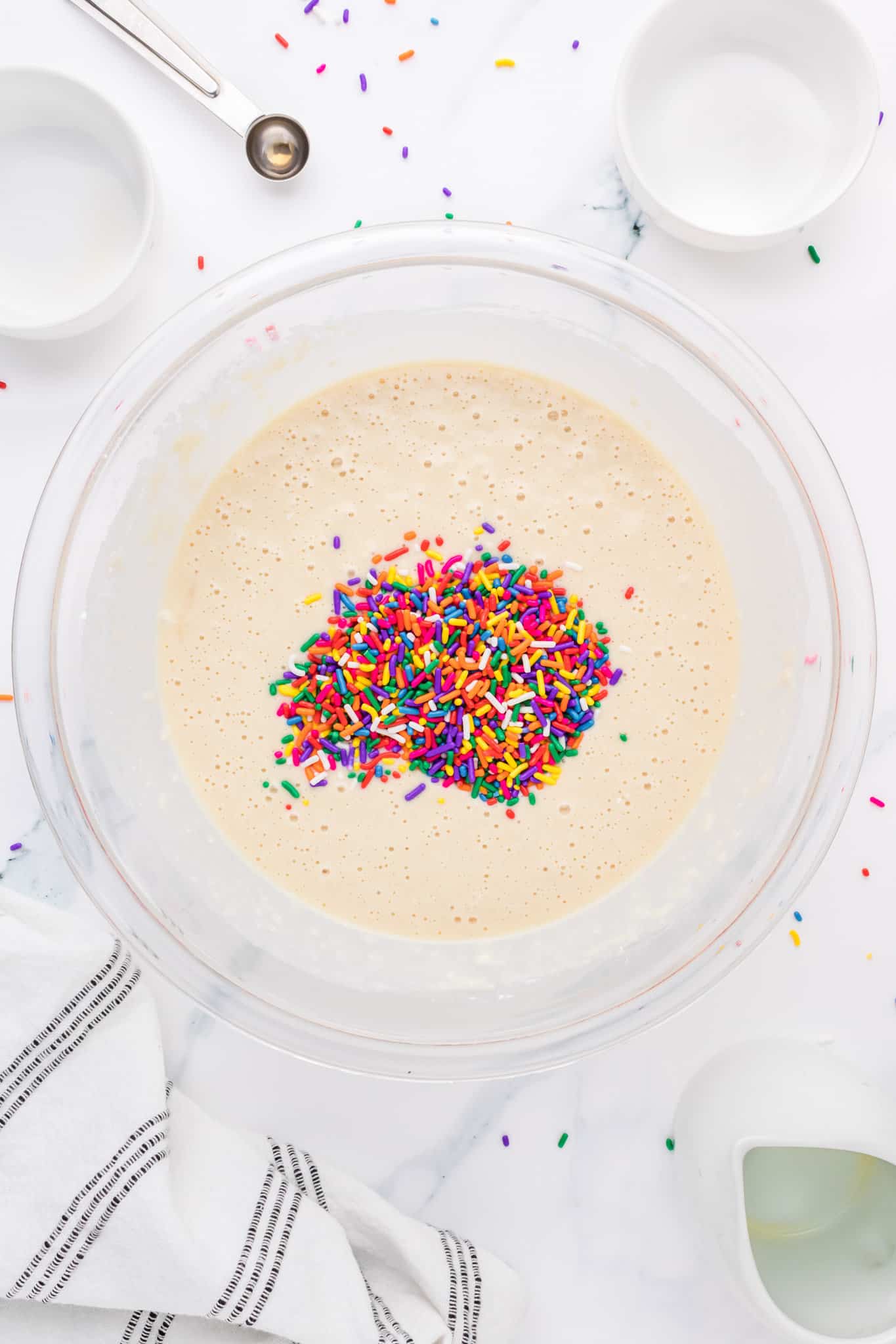 sprinkles added to pancake batter in a mixing bowl