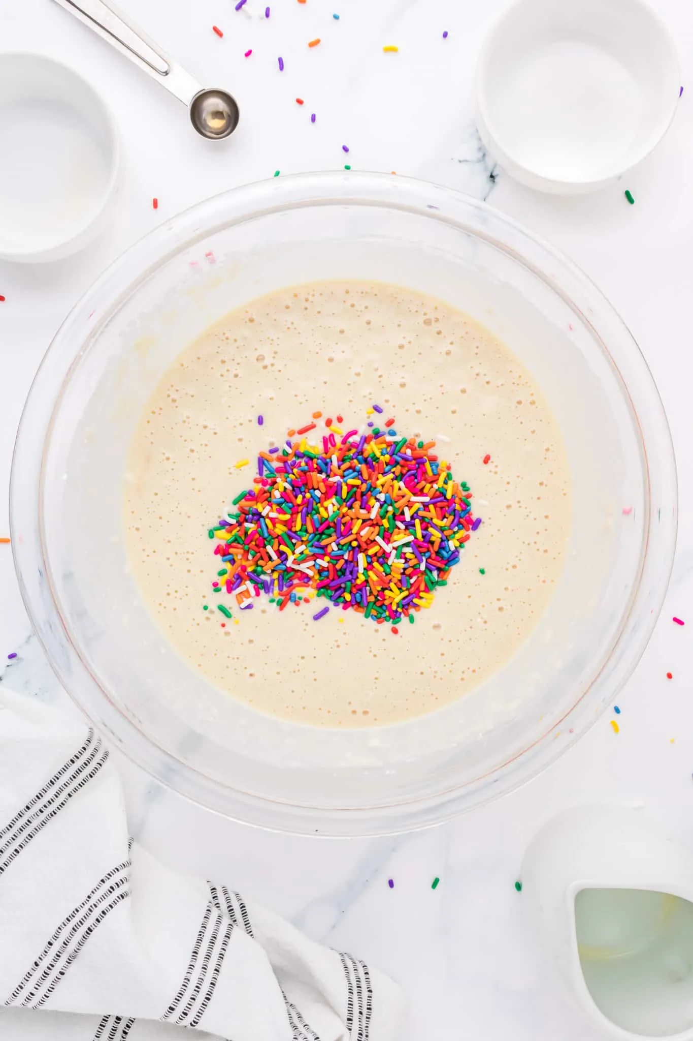 sprinkles added to pancake batter in a mixing bowl