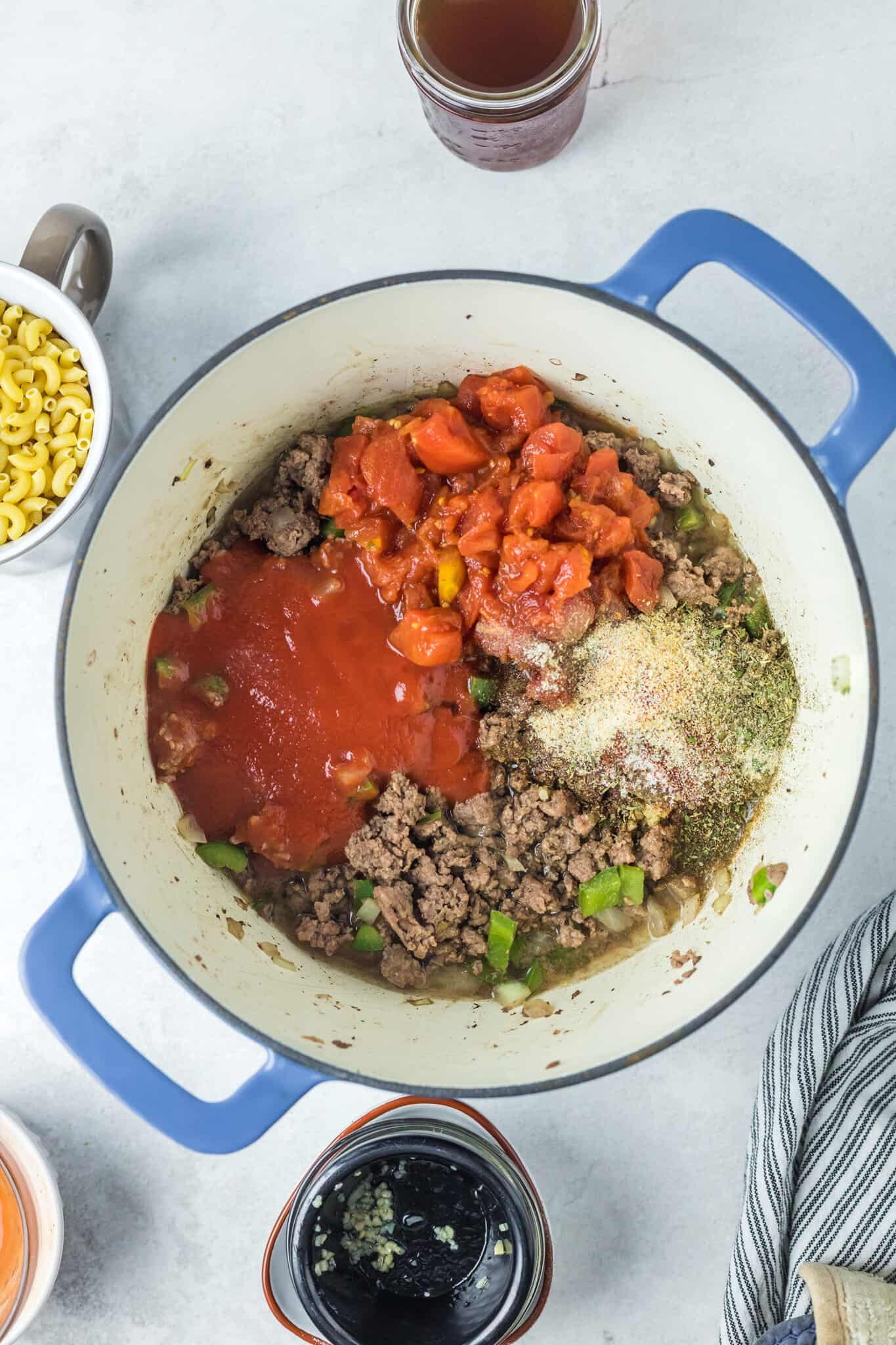 diced tomatoes, tomato sauce and spices added to pot with cooked ground beef