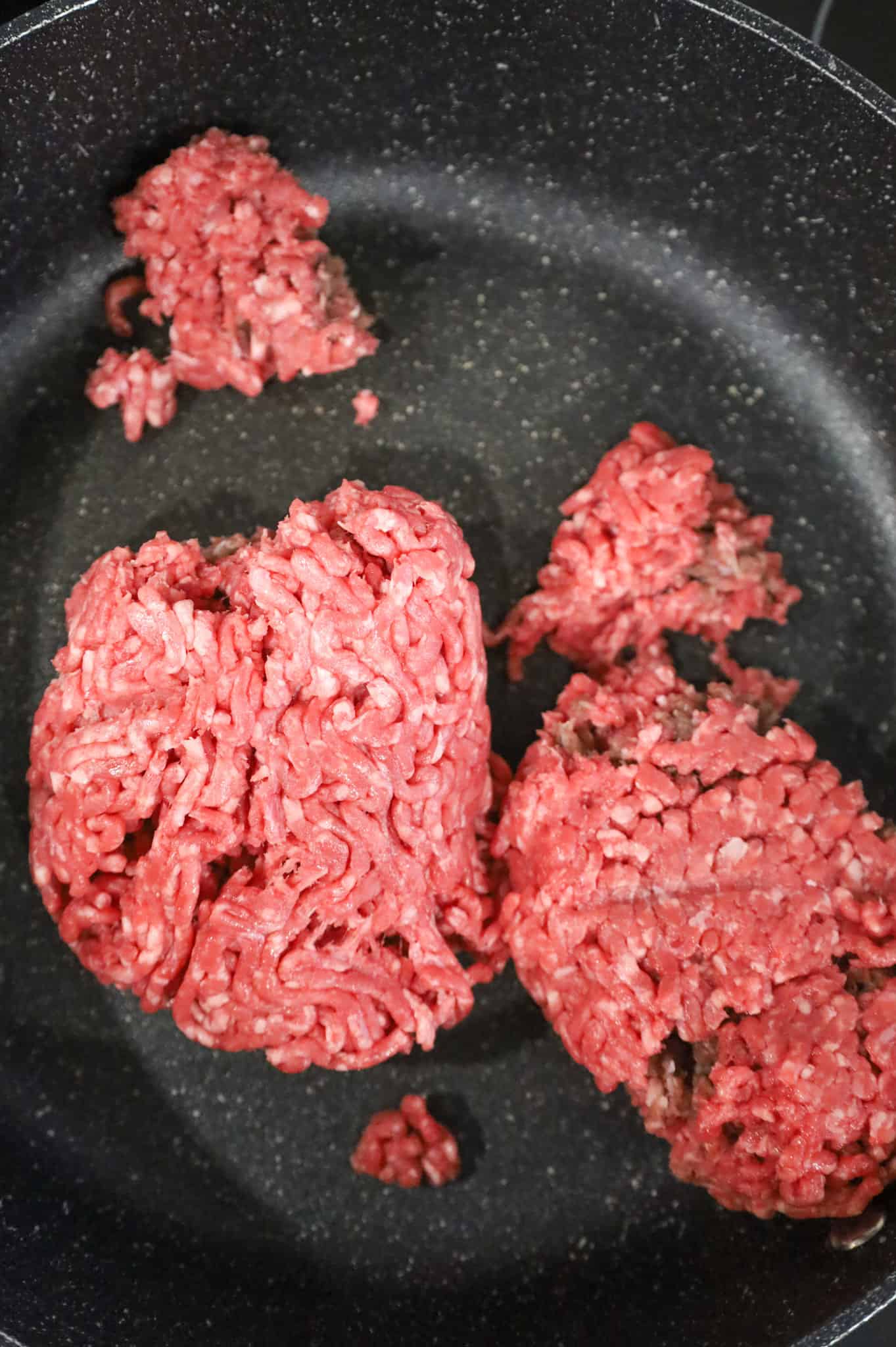 raw ground beef in a saute pan