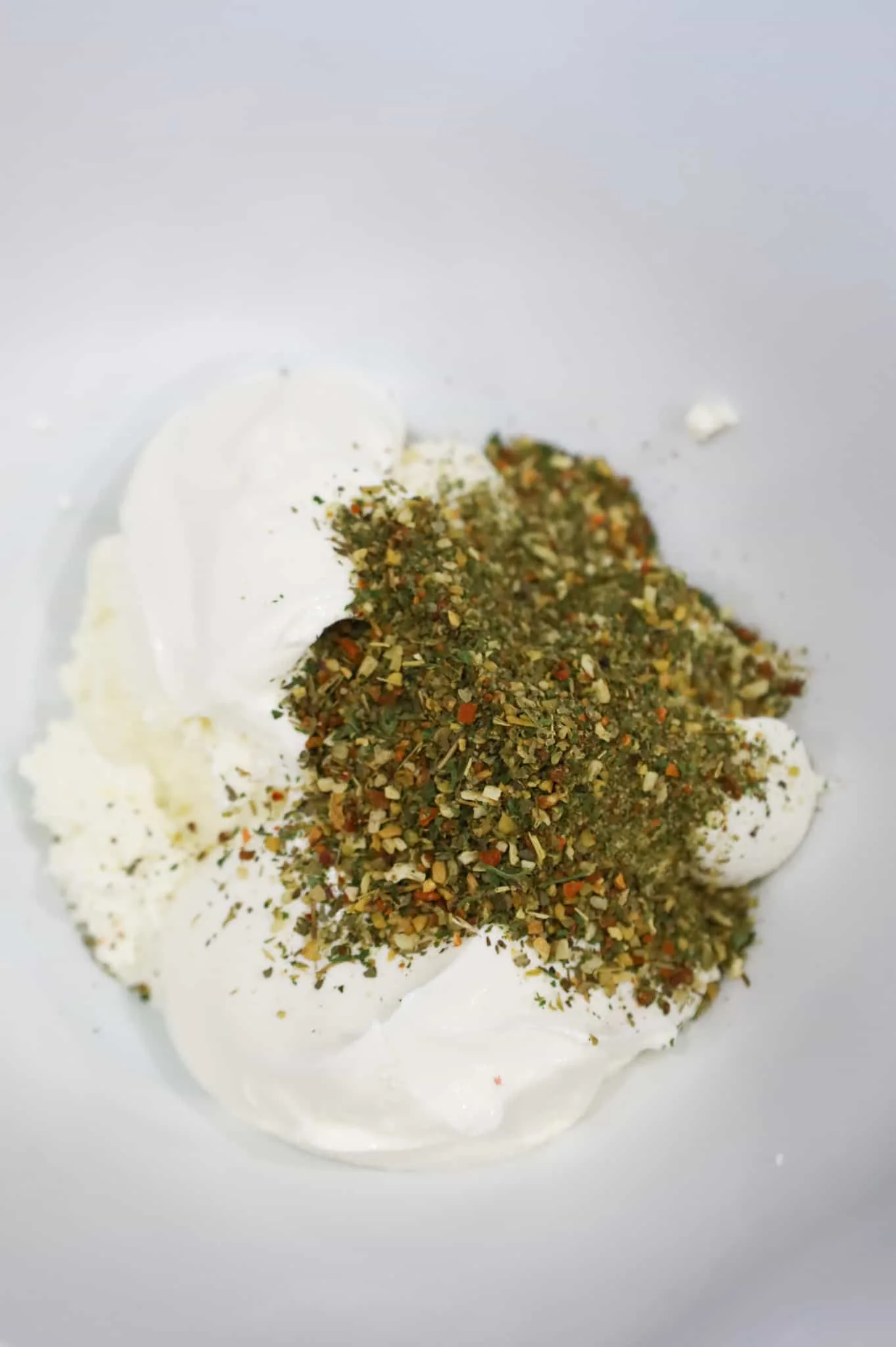 italian seasoning, sour cream and ricotta in a mixing bowl