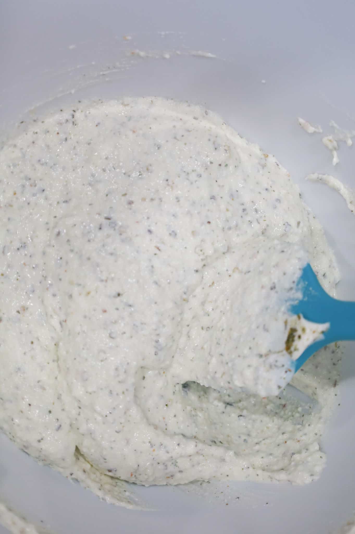 ricotta, sour cram and italian seasoning mixture in a mixing bowl