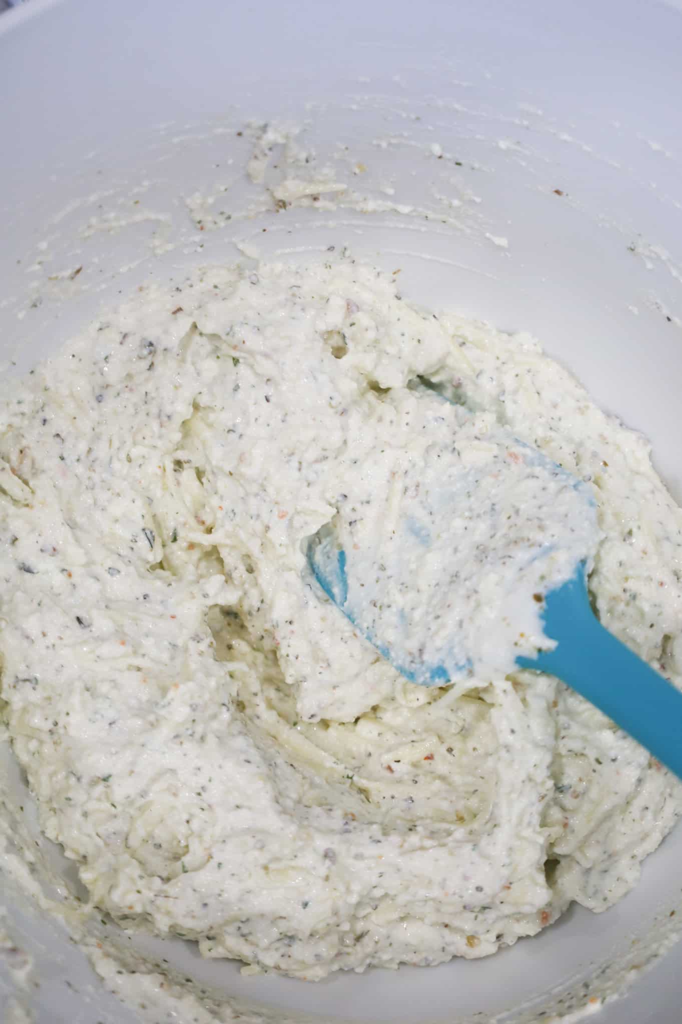 ricotta and shredded cheese mixture in a mixing bowl