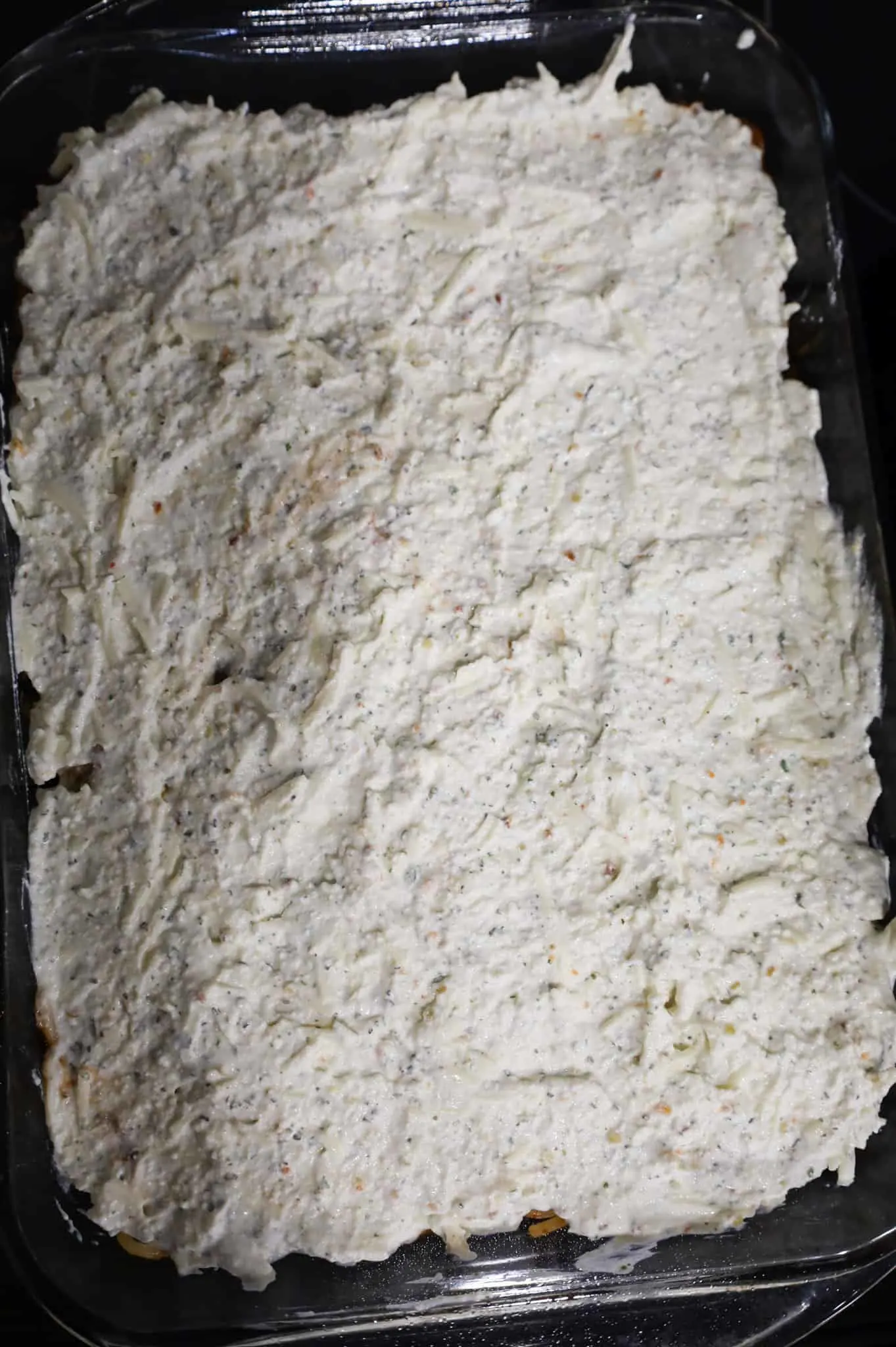 ricotta mixture on top of spaghetti in a baking dish