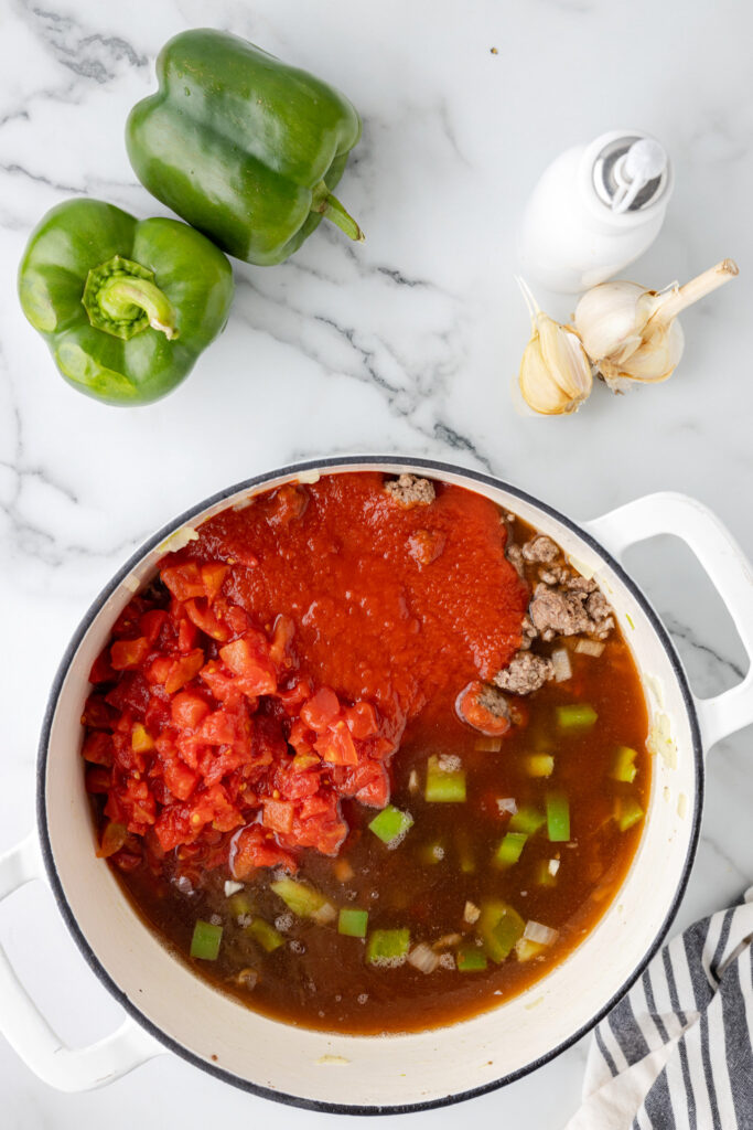 beef broth, tomato sauce and diced tomatoes added to pot with cooked ground beef and diced peppers