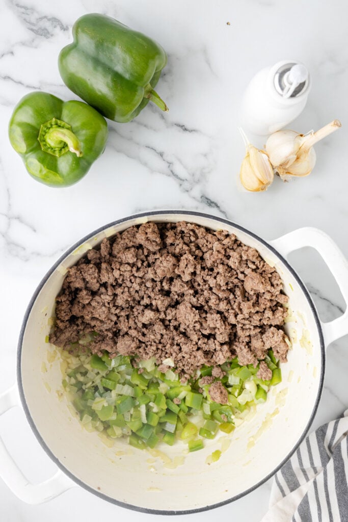 cooked ground beef added to pot with diced onion and diced peppers