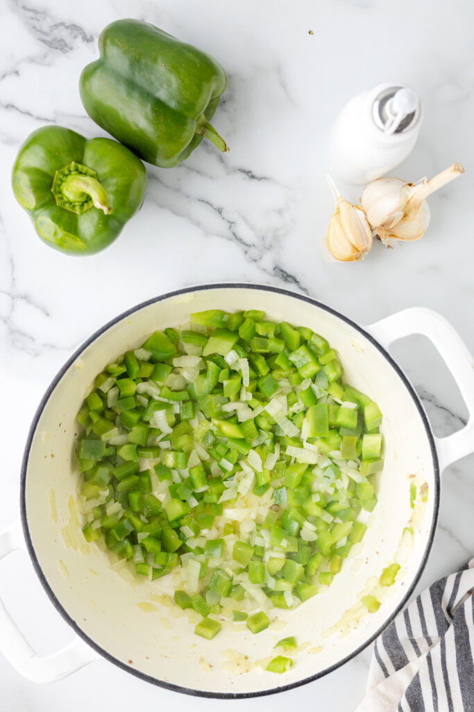diced peppers and diced onions cooking in a pot