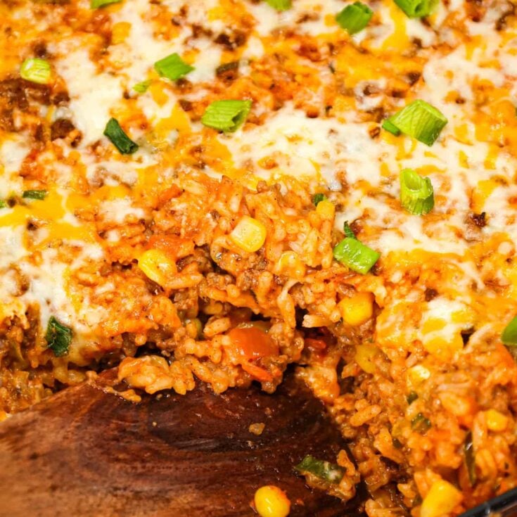 Taco Rice Casserole is a hearty ground beef casserole loaded with instant rice, condensed cheddar soup, corn, salsa, taco seasoning, ranch dressing mix, chopped green onions and a shredded Mexican cheese blend.