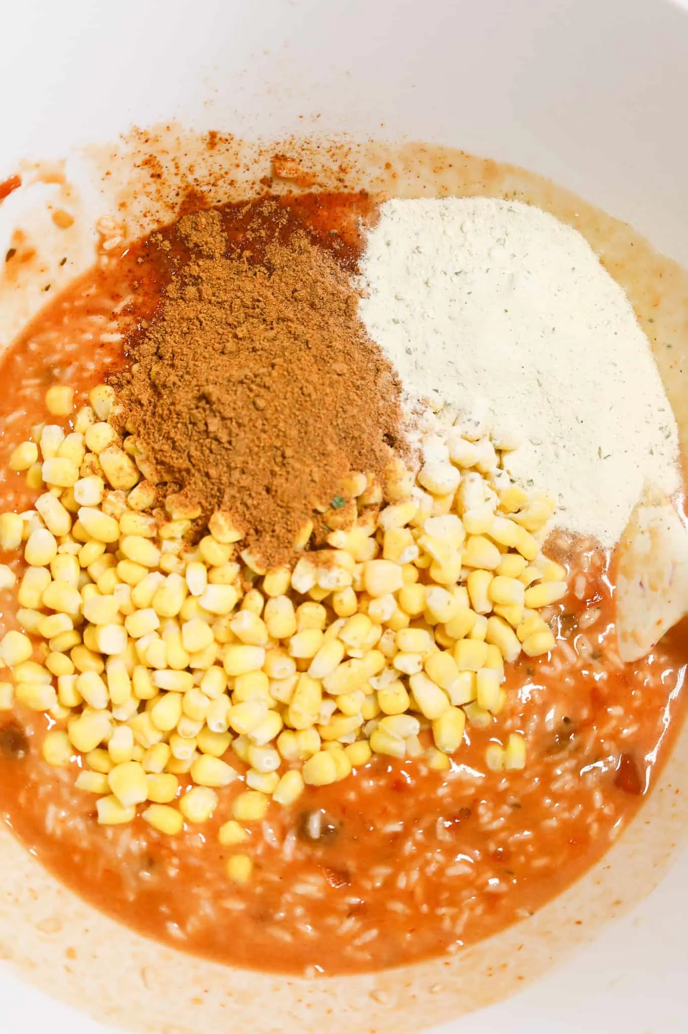 taco seasoning, ranch dressing mix and corn on top of salsa and rice mixture in a mixing bowl
