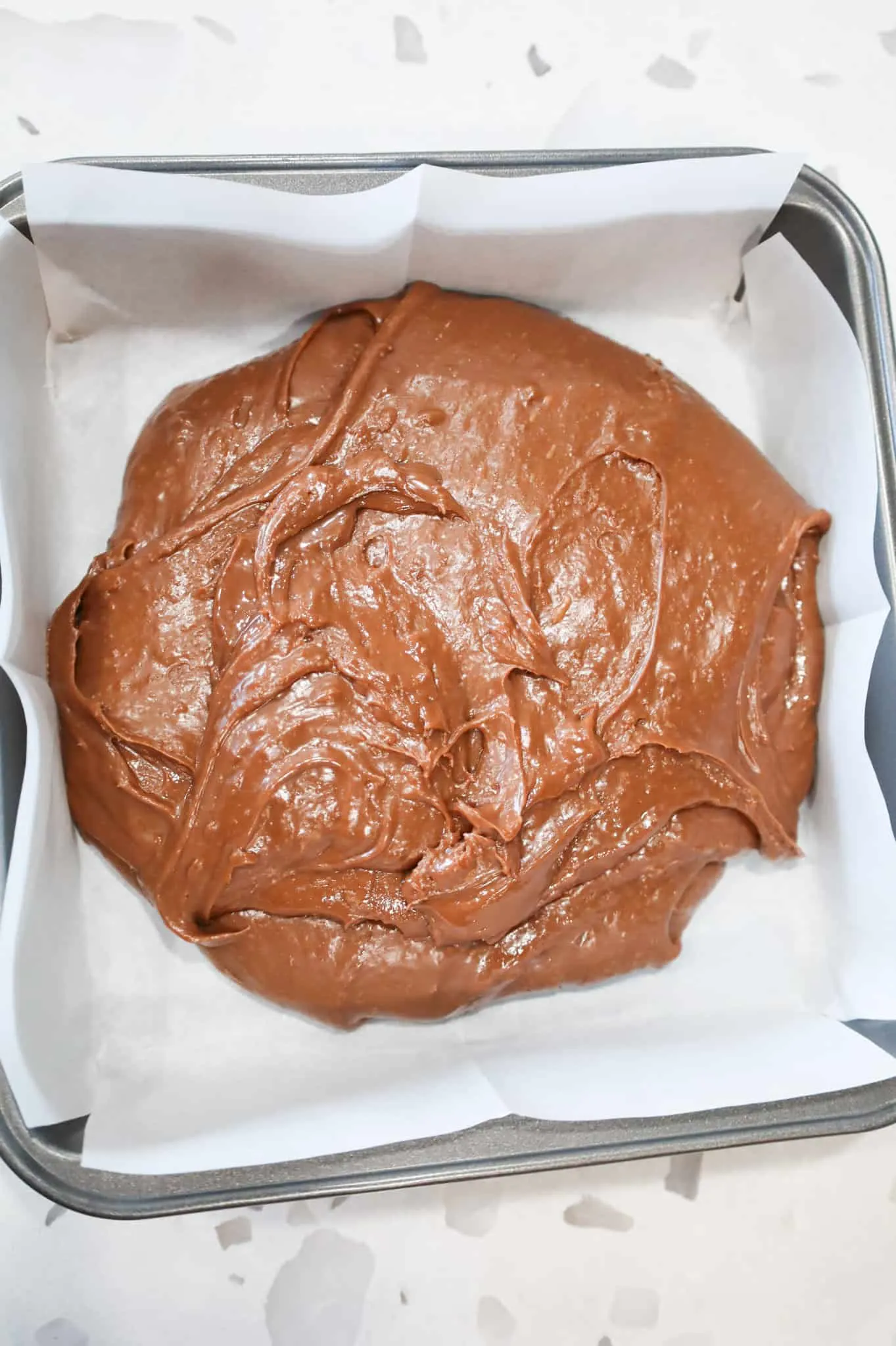 milk chocolate mixture in a parchment lined baking pan
