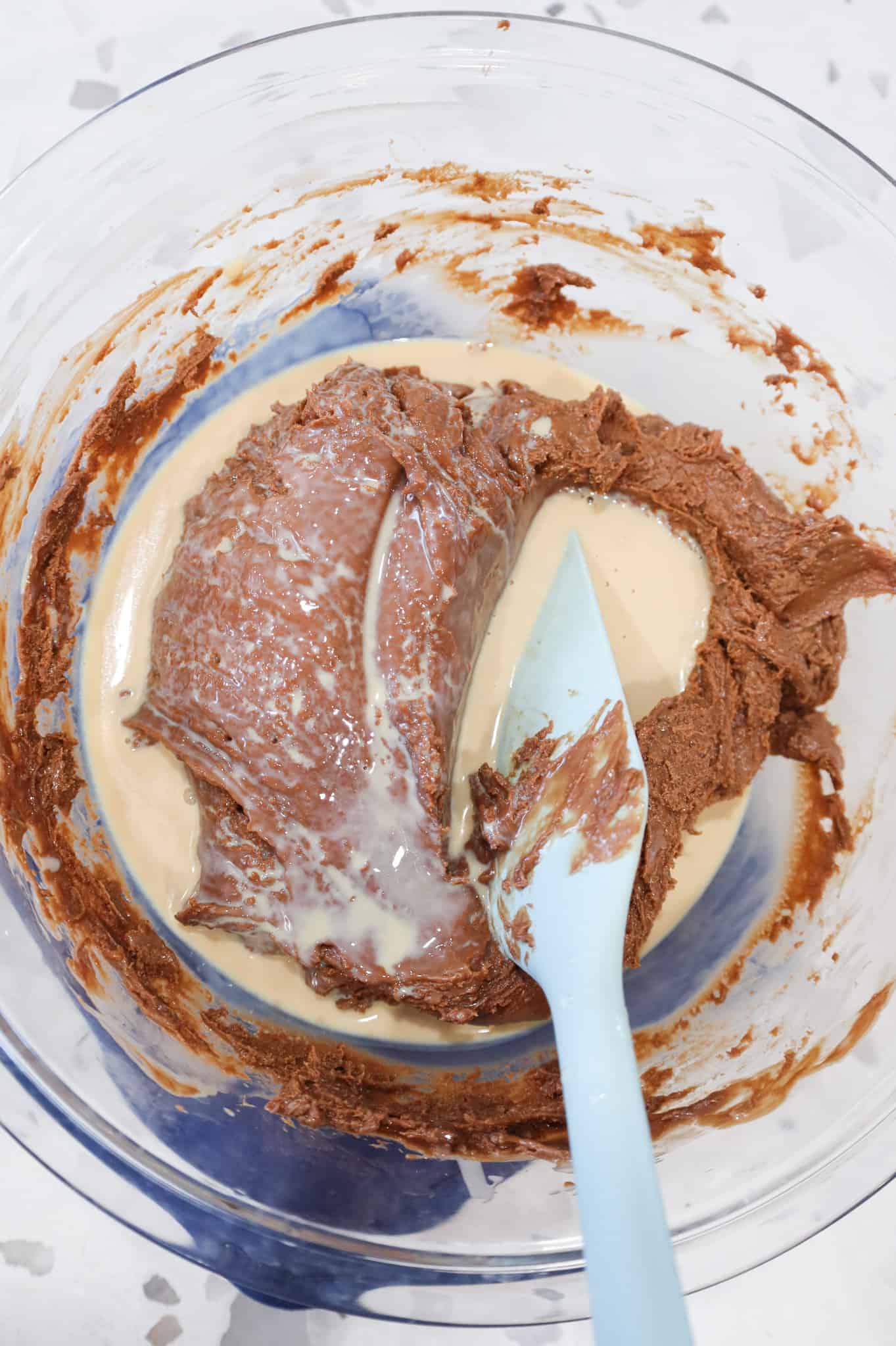 Bailey's Irish cream added to bowl with milk chocolate mixture