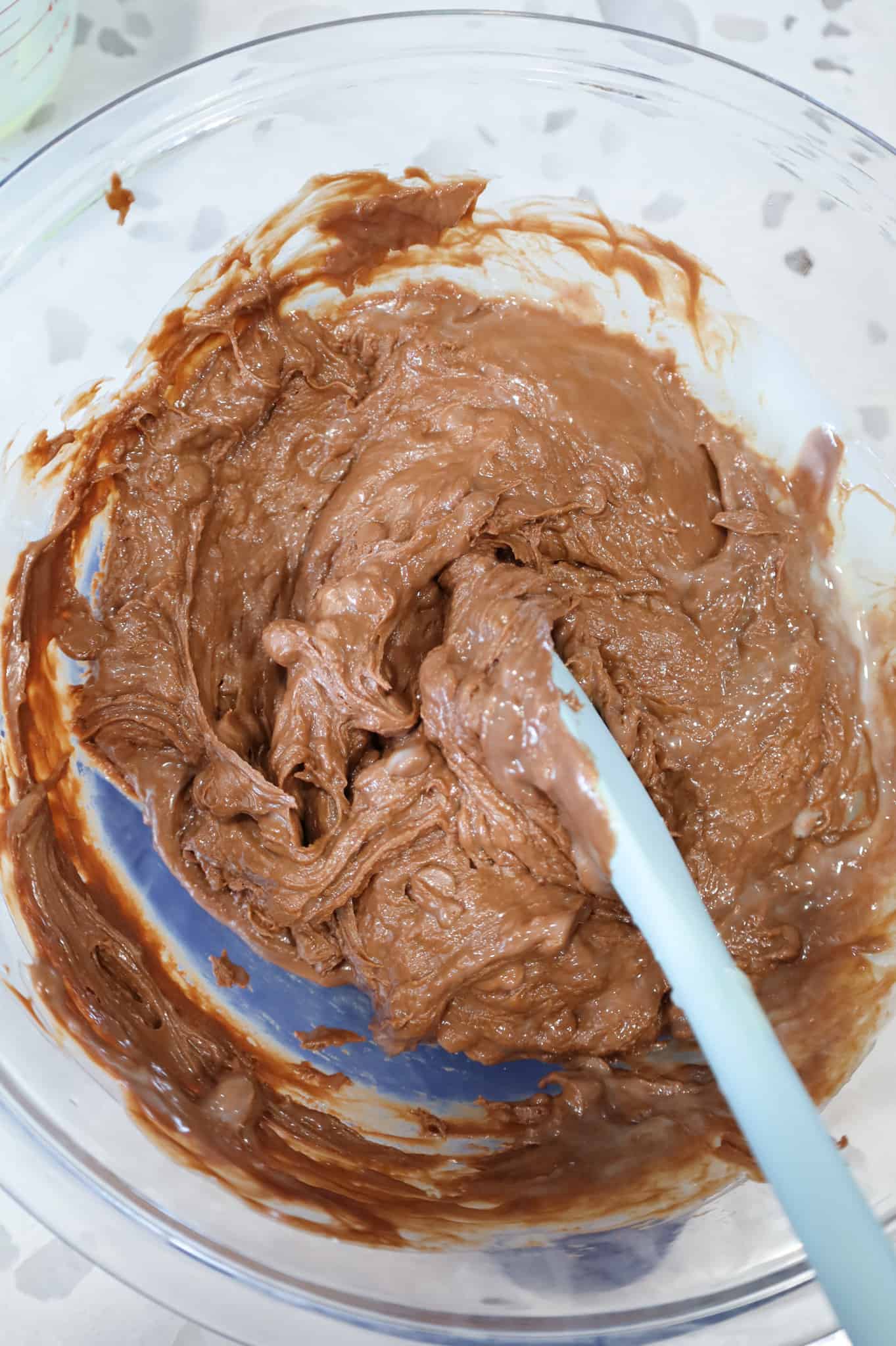 milk chocolate and sweetened condensed milk mixture being stirring in a bowl