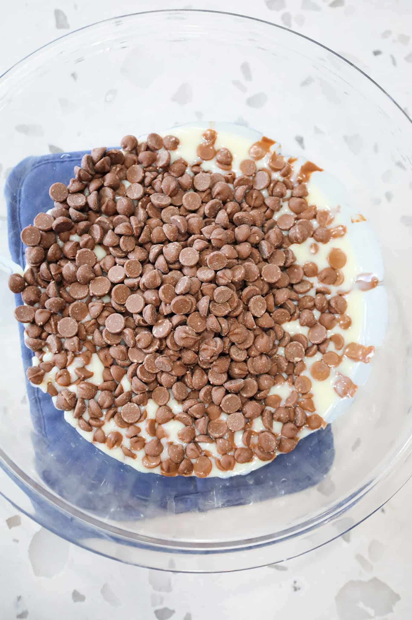 milk chocolate chips and sweetened condensed milk in a bowl after microwaving