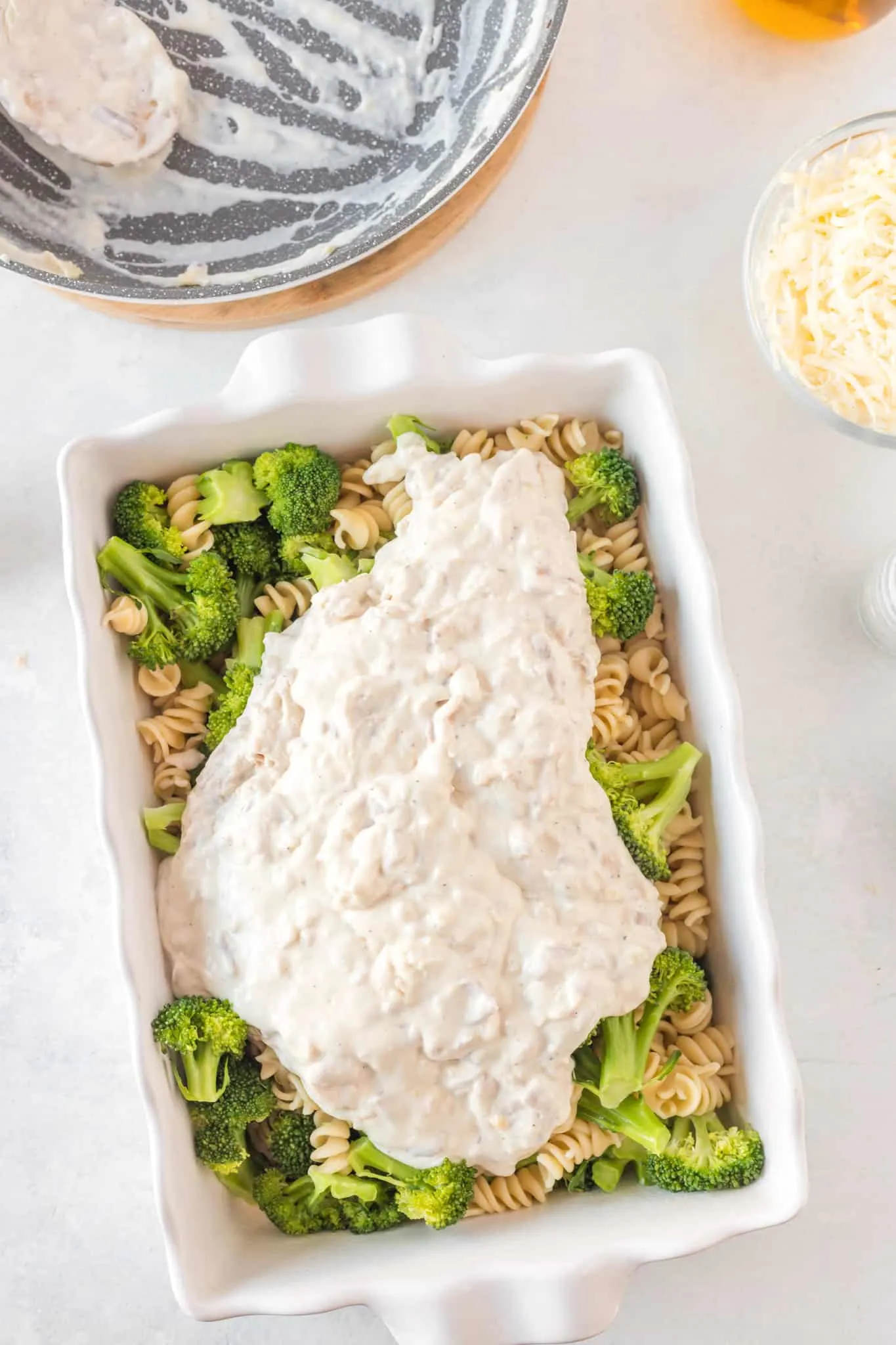 creamy chicken mixture poured over chicken and broccoli in a baking dish