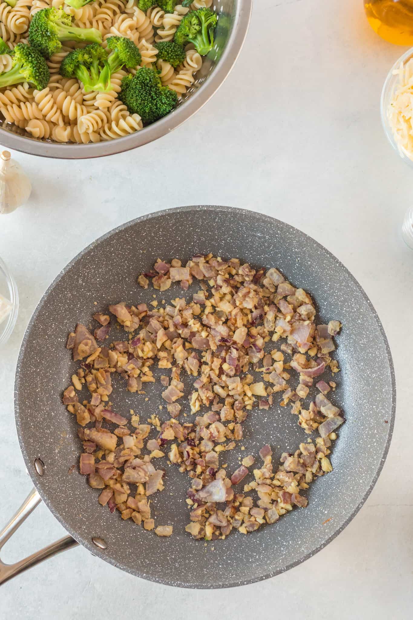 diced red onions and minced garlic cooking in a pan