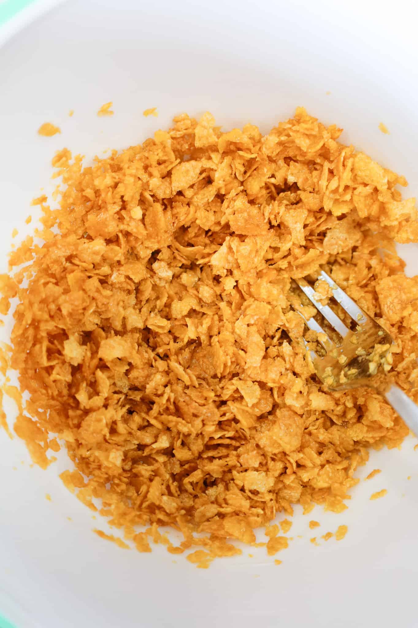 crumbled cornflake and butter mixture in a mixing bowl