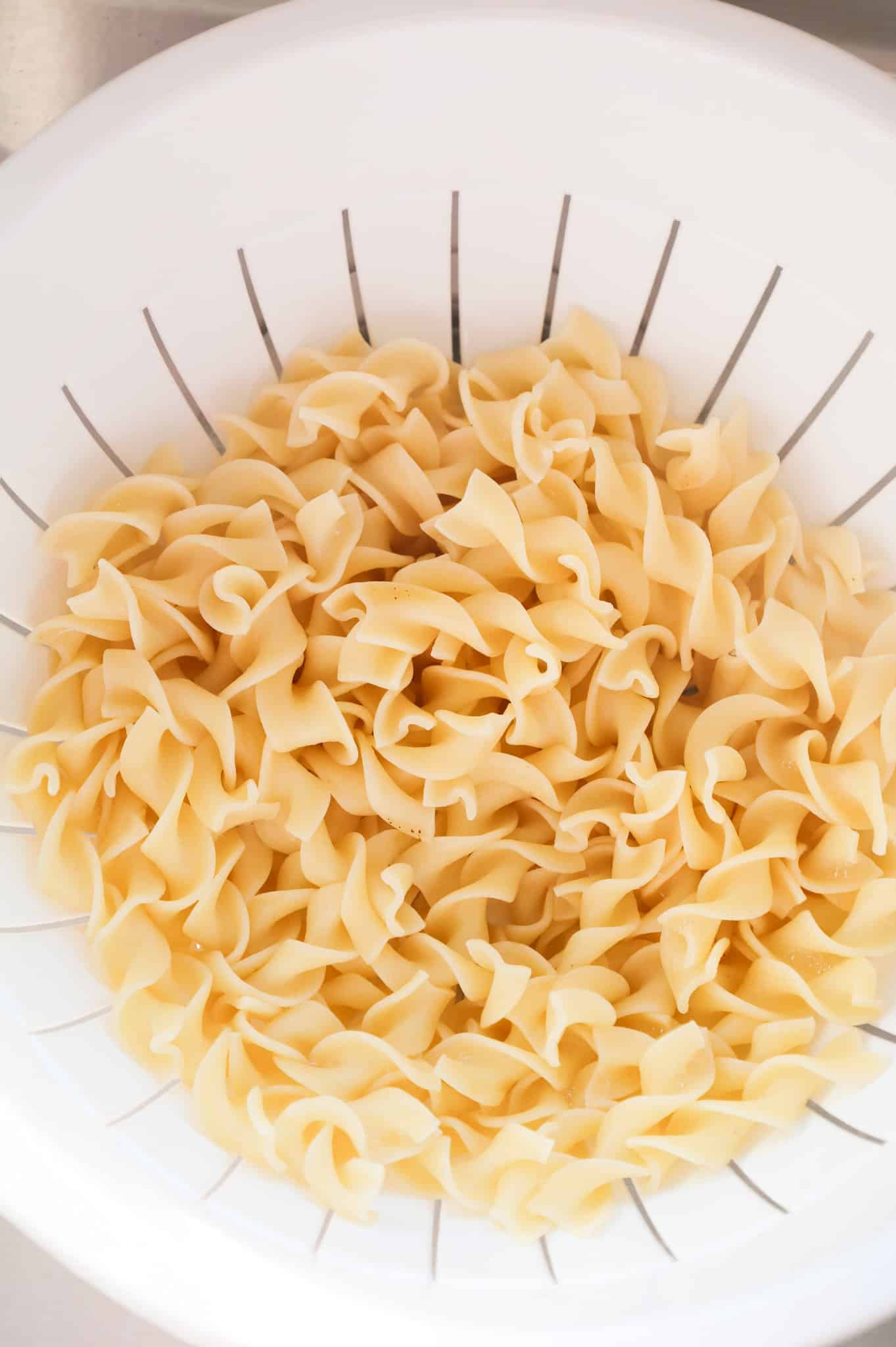 cooked egg noodles in a colander