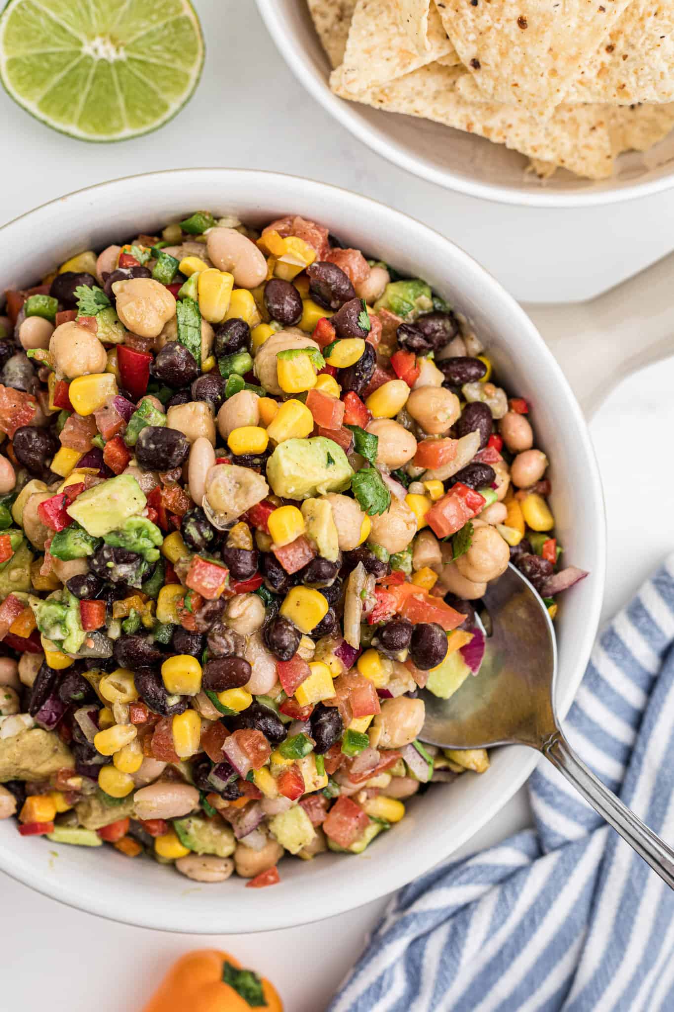 Cowboy Caviar is a delicious cold dip recipe loaded with a variety of beans, avocado, tomatoes, corn, peppers, onions and fresh cilantro.