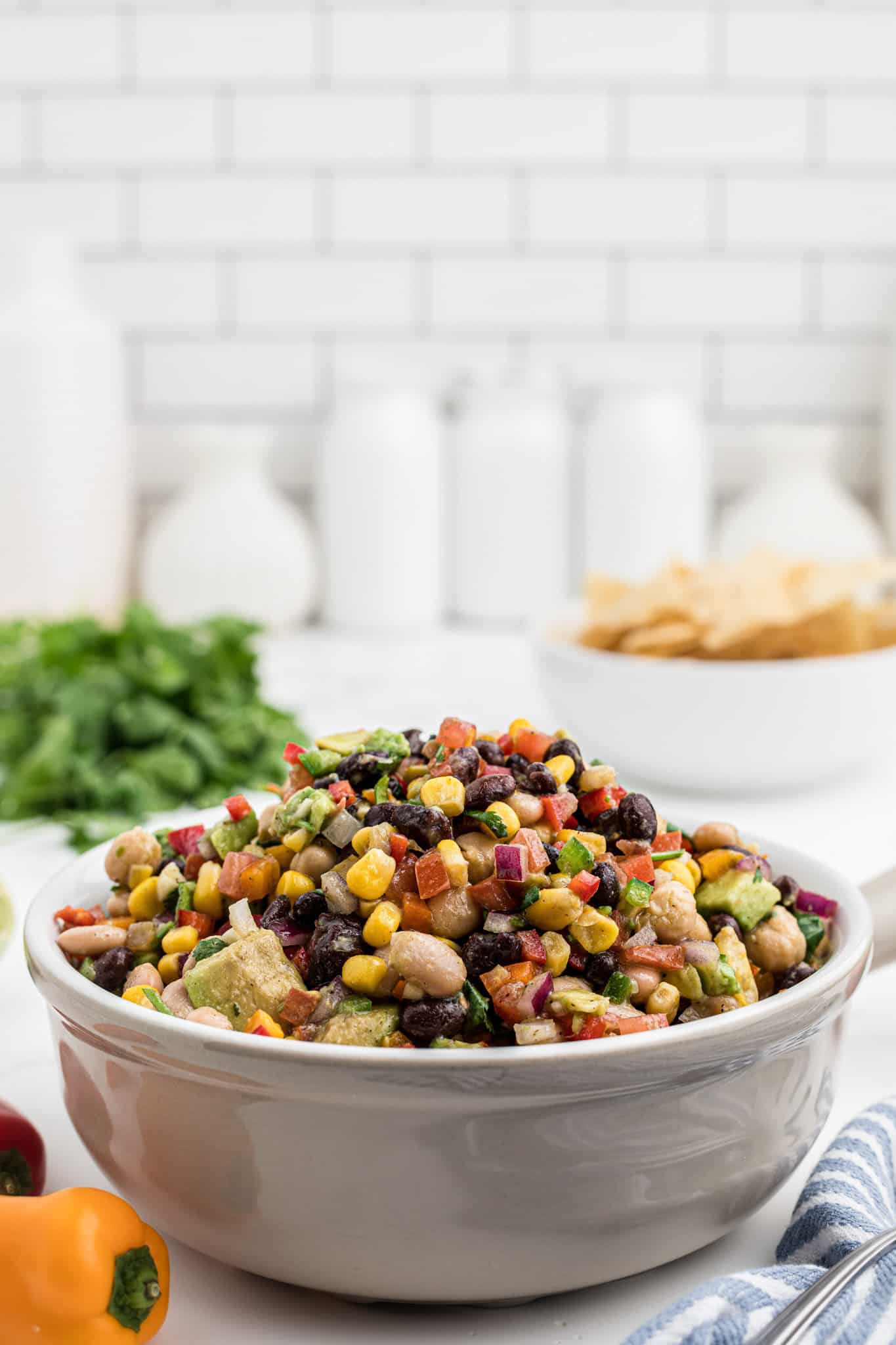 Cowboy Caviar is a delicious cold dip recipe loaded with a variety of beans, avocado, tomatoes, corn, peppers, onions and fresh cilantro.