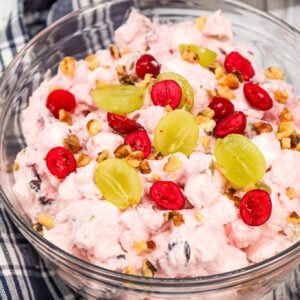 Cranberry Fluff is a delicious Thanksgiving side dish recipe made with whole berry cranberry sauce, chopped green grapes, Cool whip, mini marshmallows and chopped walnuts.