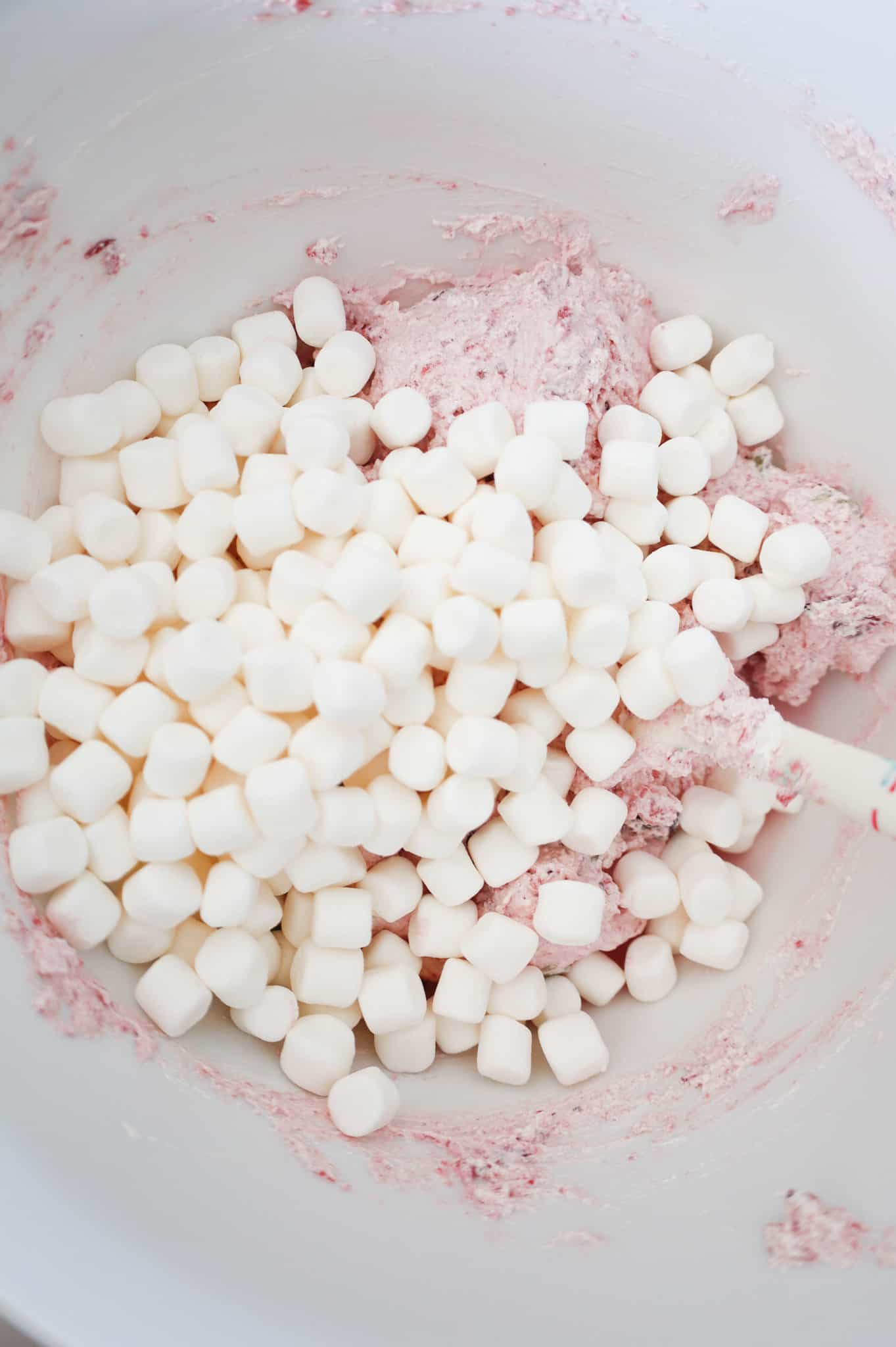 mini marshmallows on top of Cool whip and cranberry sauce mixture in a mixing bowl