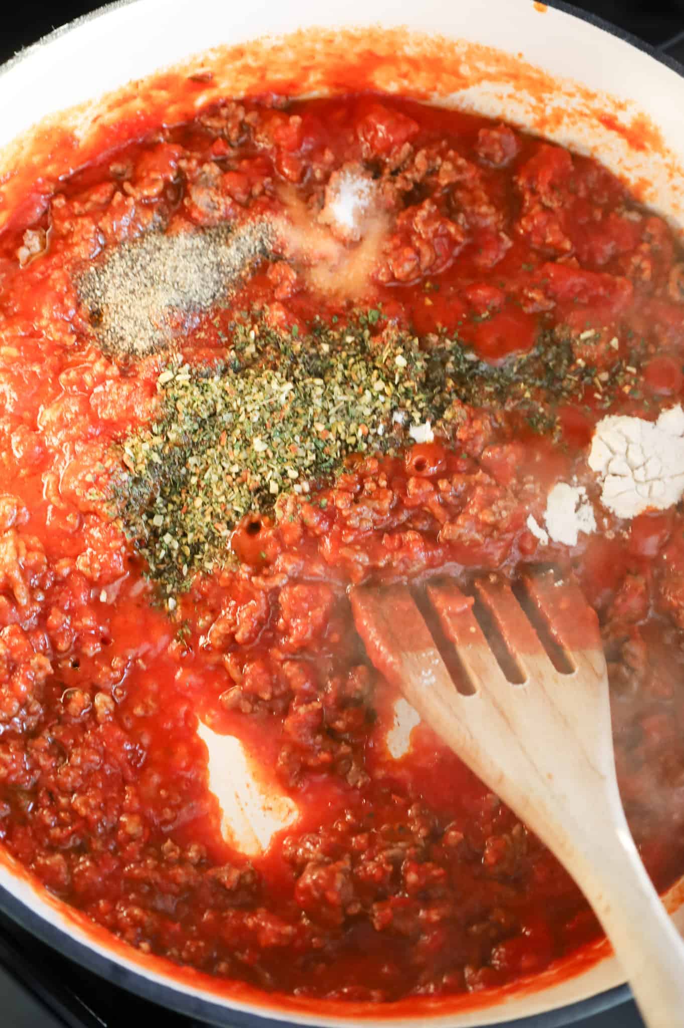 Italian seasoning, salt, pepper and onion powder on top of marinara and ground beef mixture in a skillet