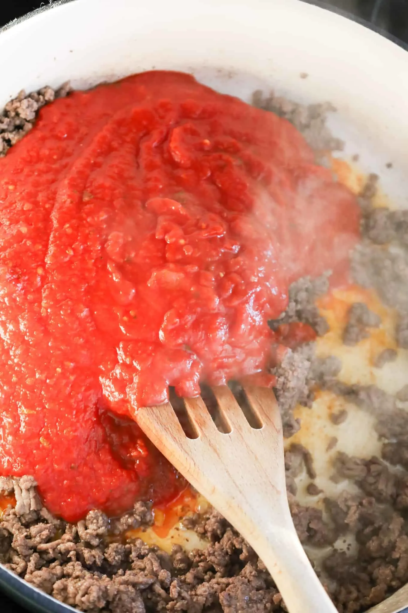 marinara sauce added to skillet with cooked ground beef
