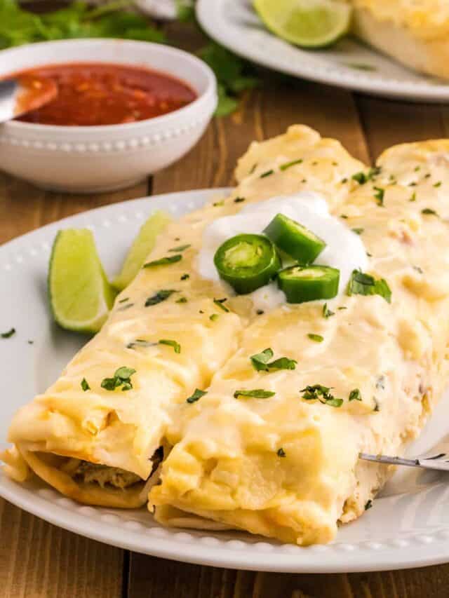 White Chicken Enchiladas are delicious baked tortillas filled with shredded chicken, cream cheese and green chilis baked in a creamy sauce and topped with cheese.