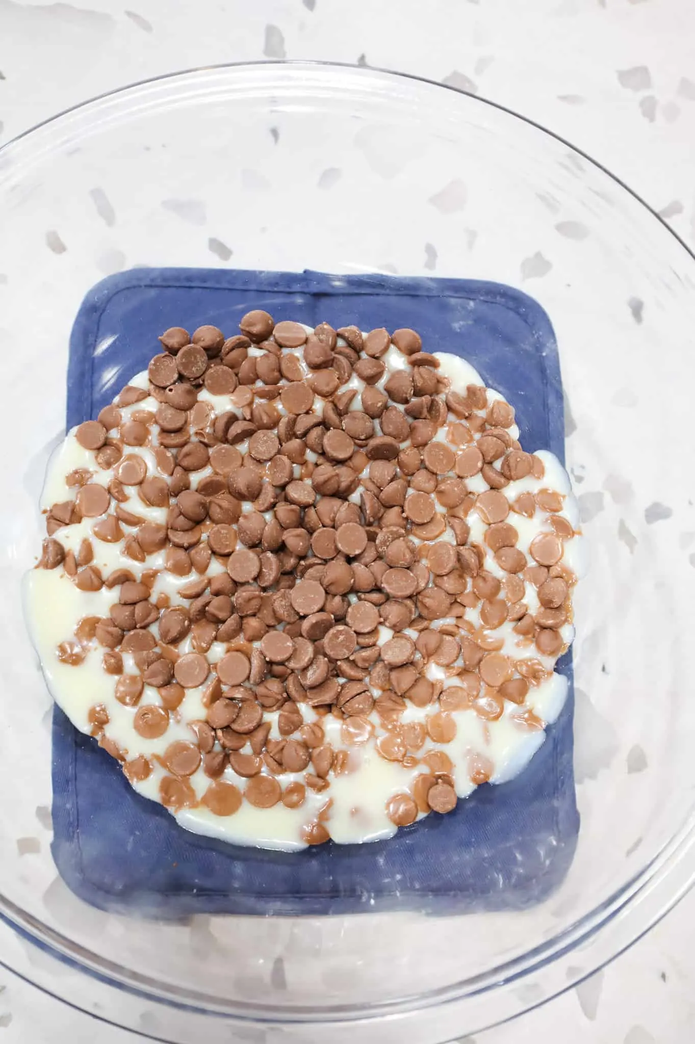 milk chocolate chips and sweetened condensed milk in a mixing bowl after microwaving