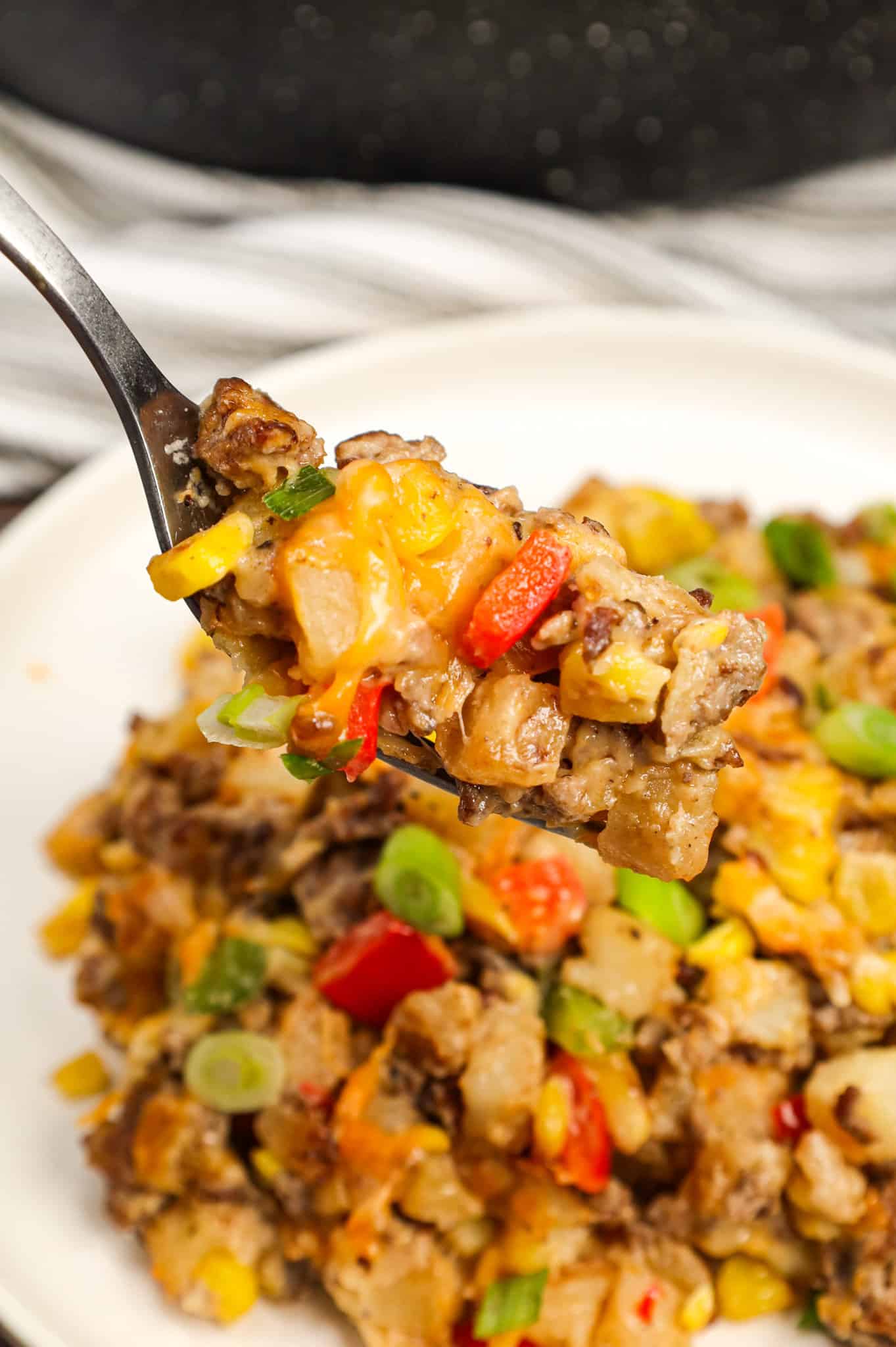 Ground Beef and Potatoes is an easy weeknight dinner recipe loaded with diced hash brown potatoes, ground beef, corn, diced bell peppers, cream of mushroom soup and shredded cheddar cheese.