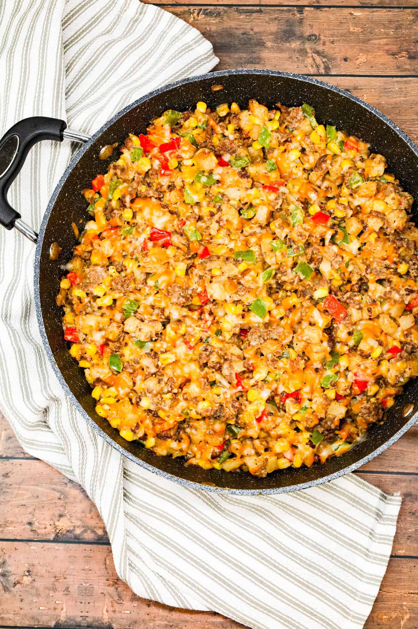 Ground Beef and Potatoes is an easy weeknight dinner recipe loaded with diced hash brown potatoes, ground beef, corn, diced bell peppers, cream of mushroom soup and shredded cheddar cheese.