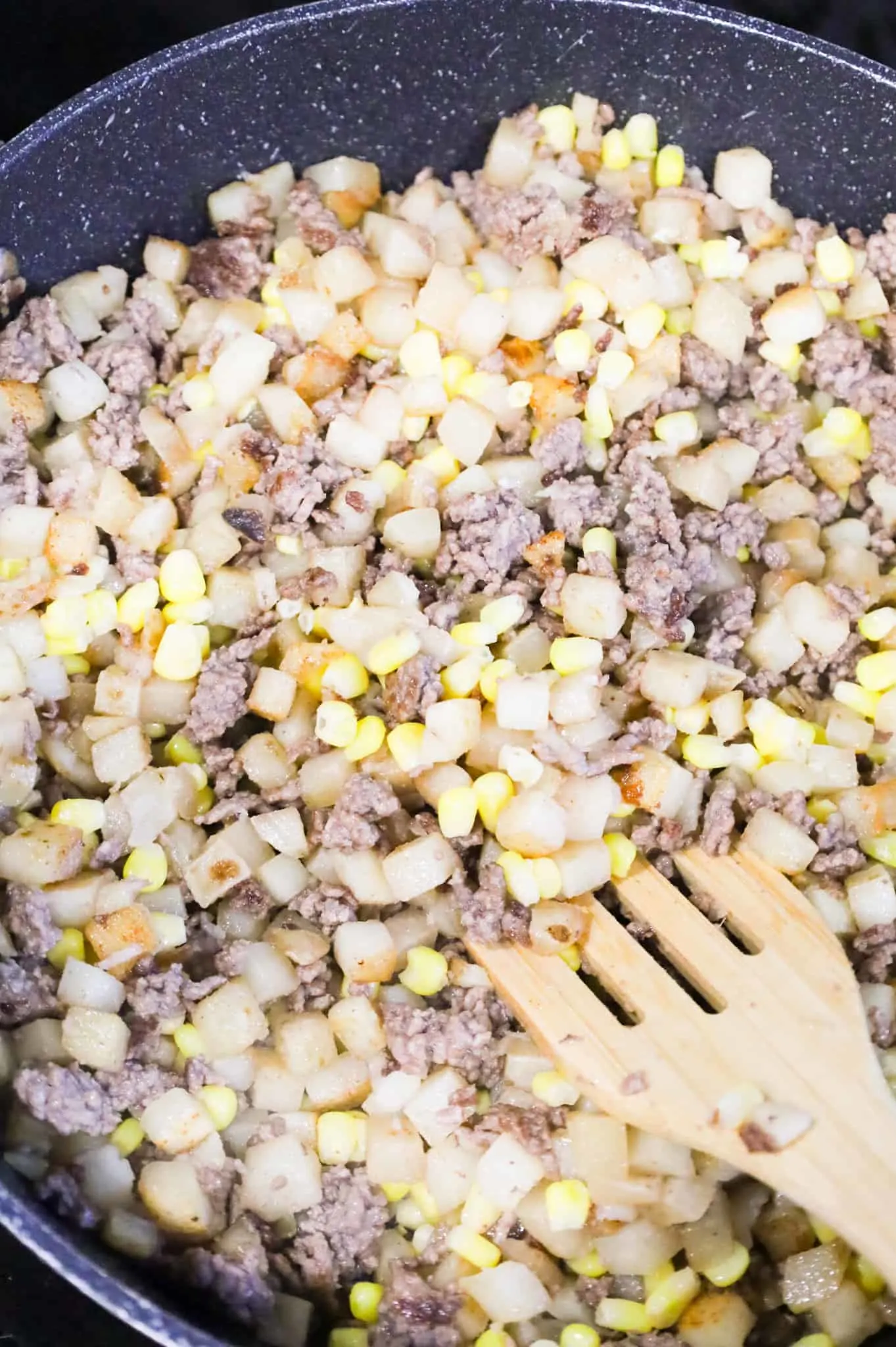 corn, ground beef and diced potatoes in a skillet