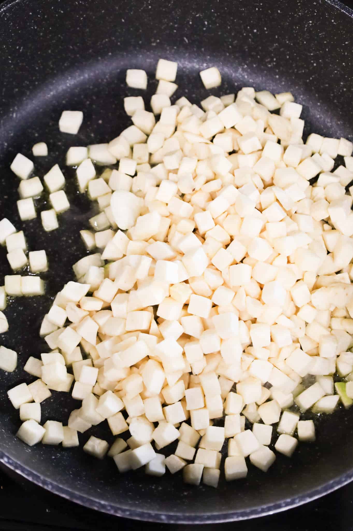 frozen diced hash brown potatoes added to a skillet