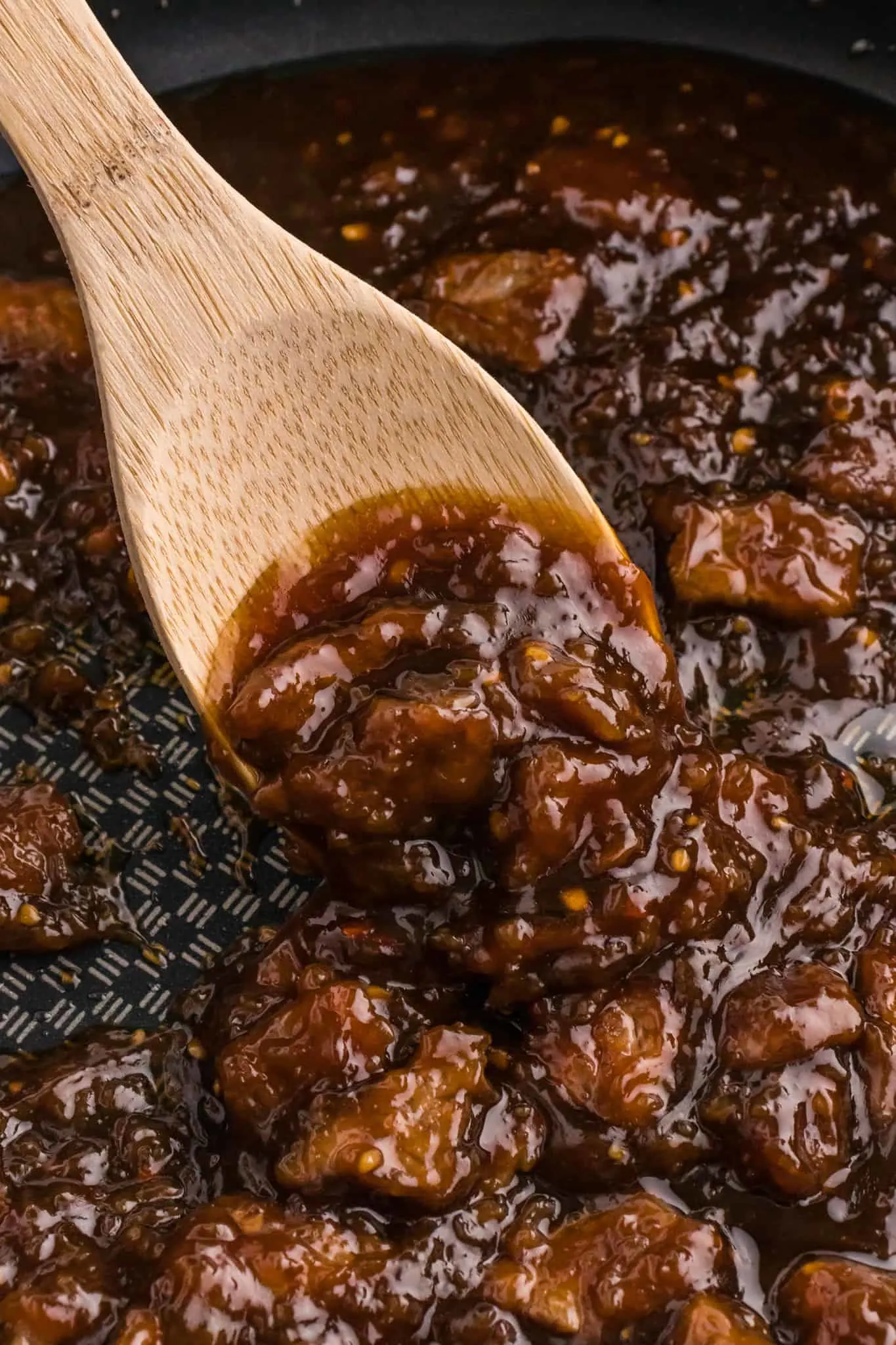 Mongolian Beef is a delicious dish with crispy fried steak strips cooked simmered in a brown sugar and soy sauce mixture served over noodles or rice and garnished with sesame seeds and green onions.