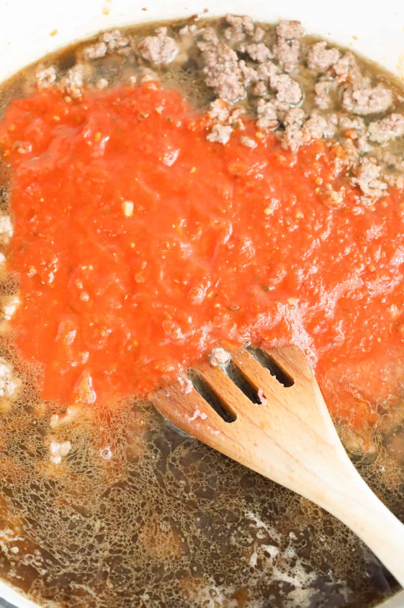 marinara sauce and beef broth added to skillet with cooked ground beef