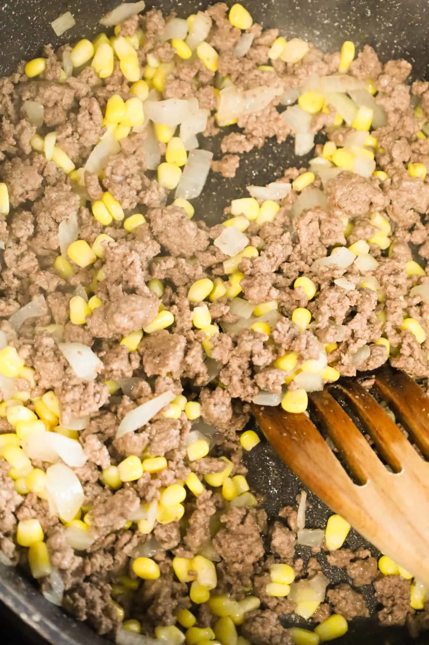 ground beef, corn and onions mixture in a skillet
