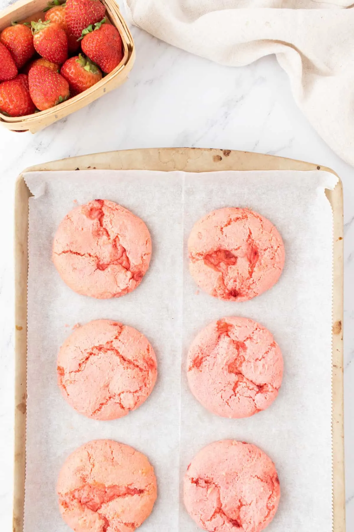 baked strawberry cookies on a parchment lined baking sheet