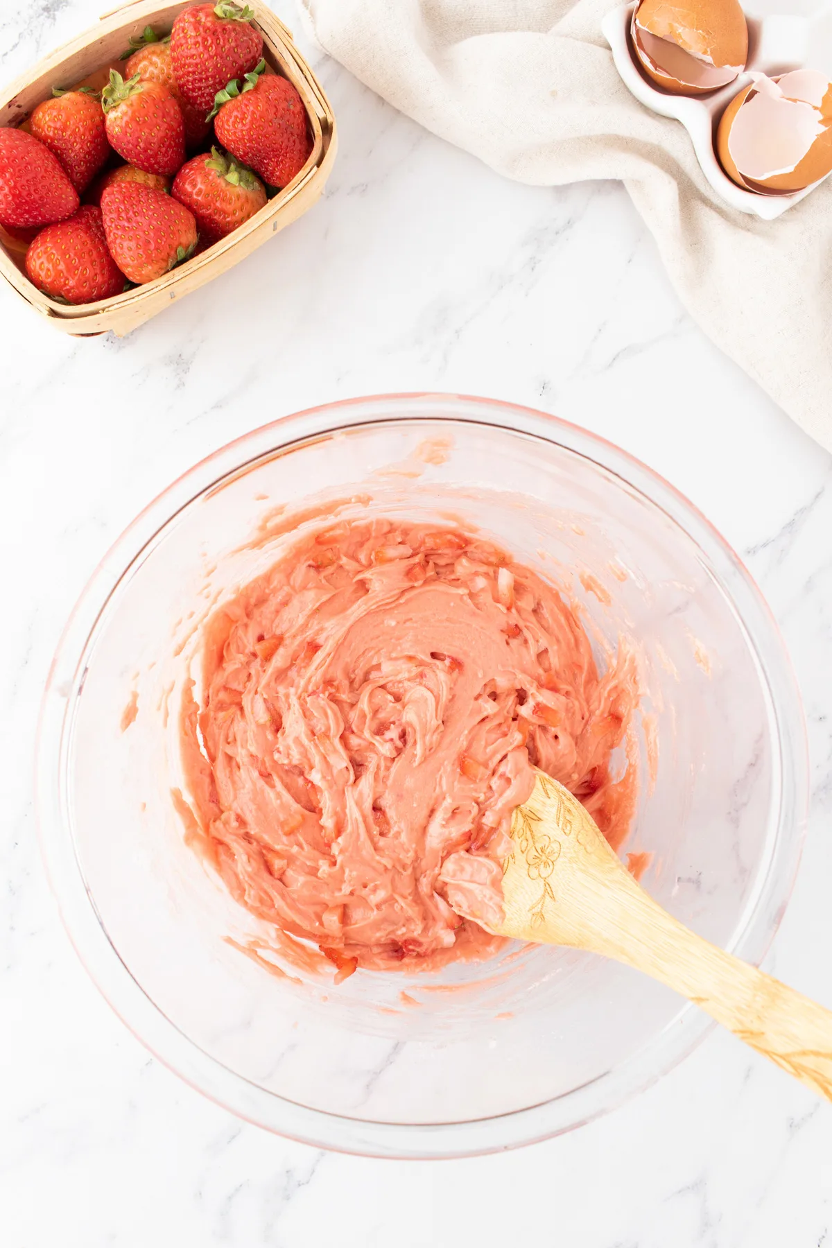 chopped strawberries being stirred into strawberry cookie batter in a bowl