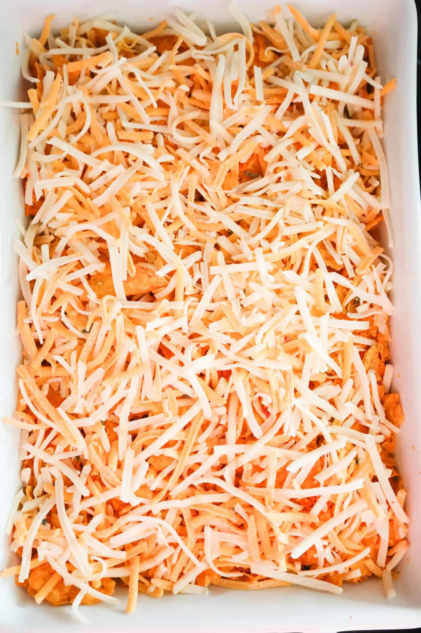 shredded cheese on top of Doritos casserole